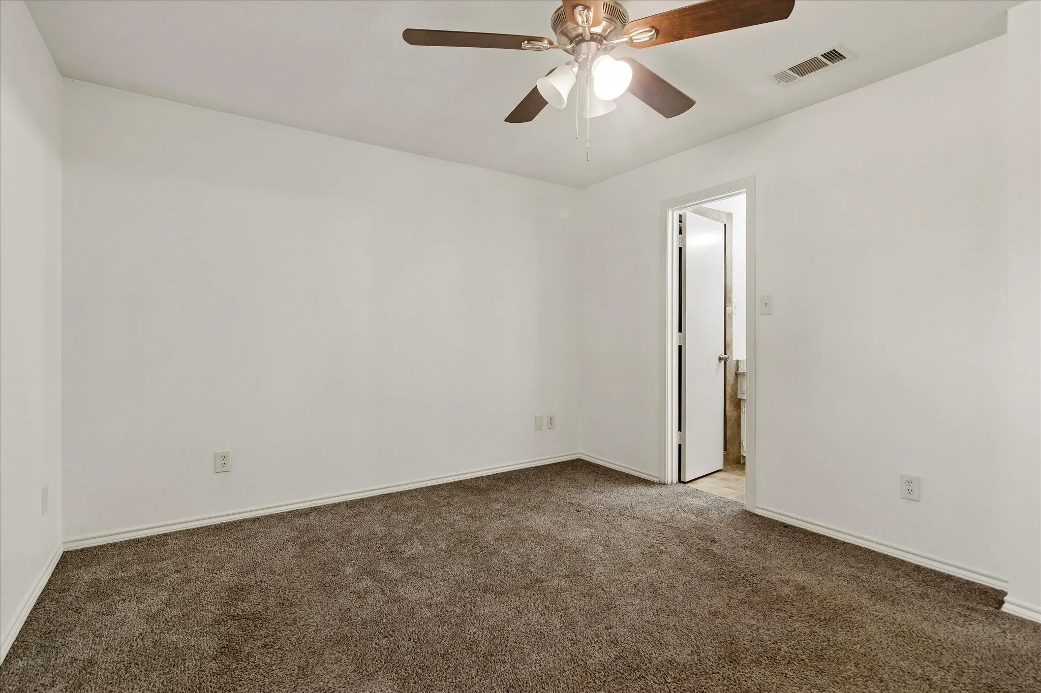Carpeted room with a ceiling fan, white walls, and white baseboards