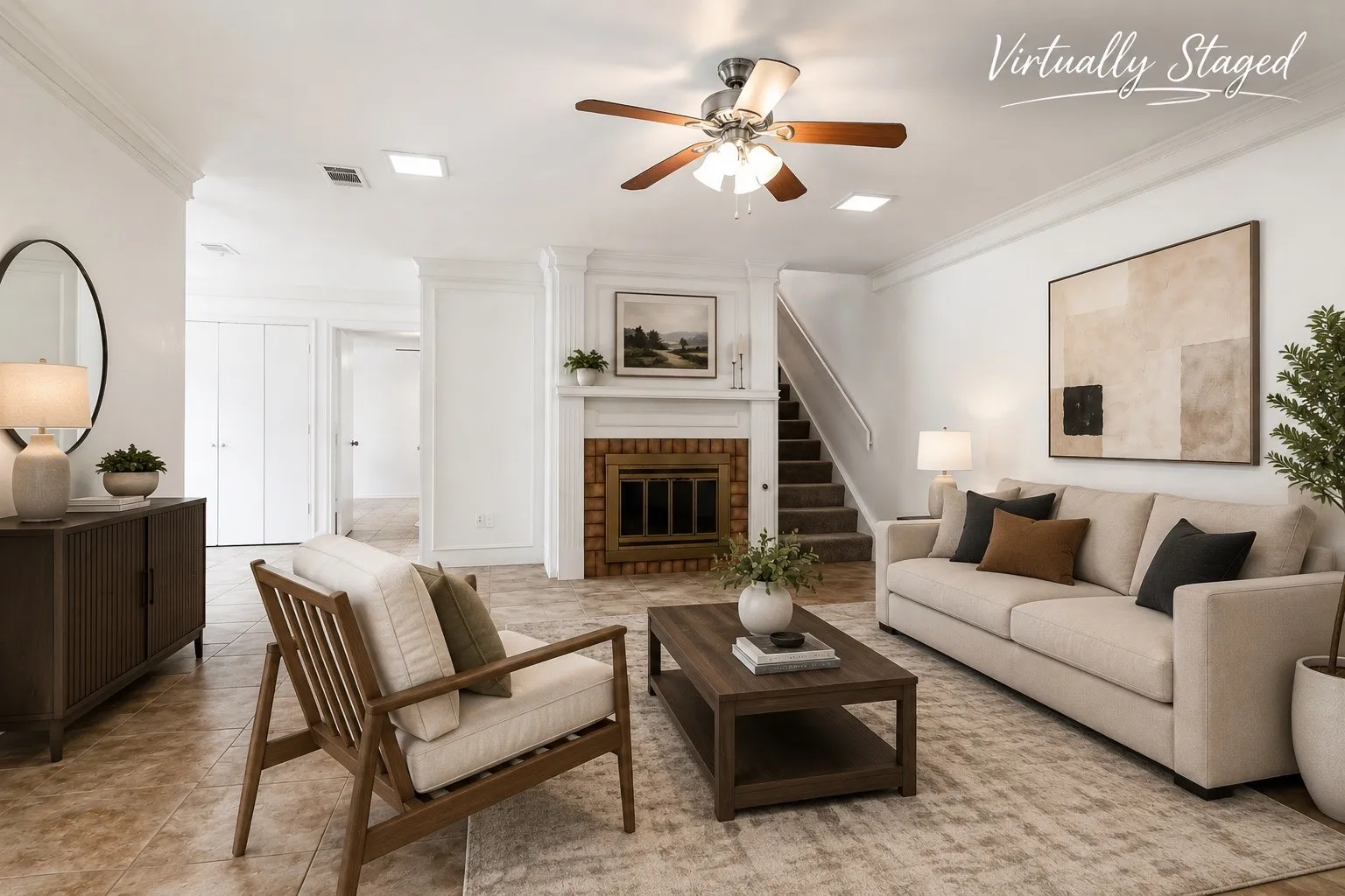 Living area featuring a white wood mantel fireplace with a brick surround, a staircase with carpeted treads, and a ceiling fan with light fixture