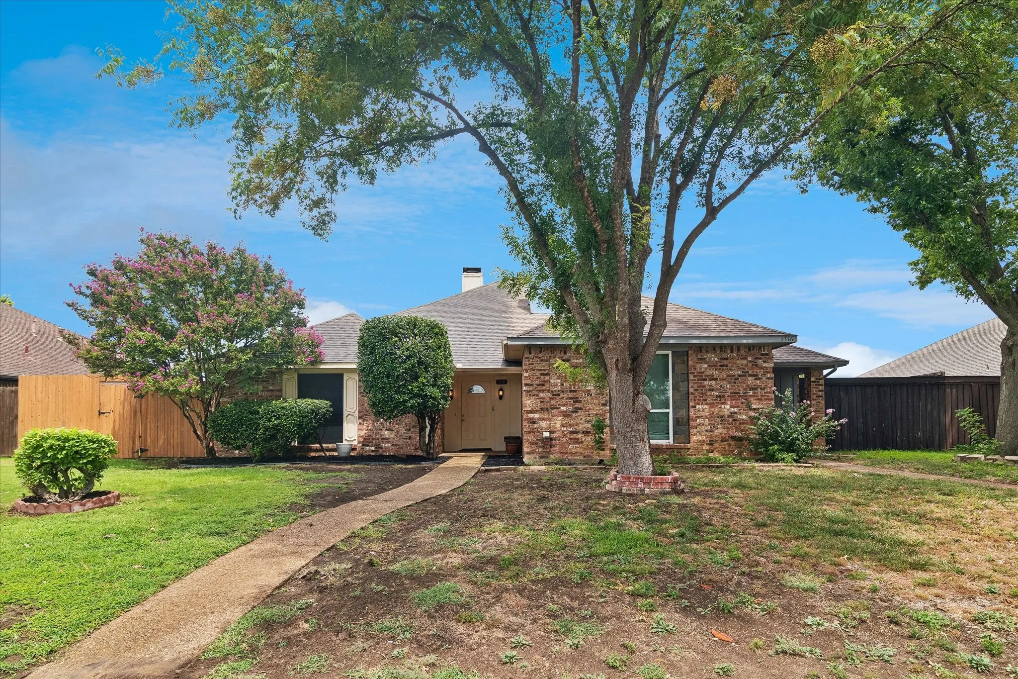 Brick exterior featuring a gabled roof and a concrete walkway