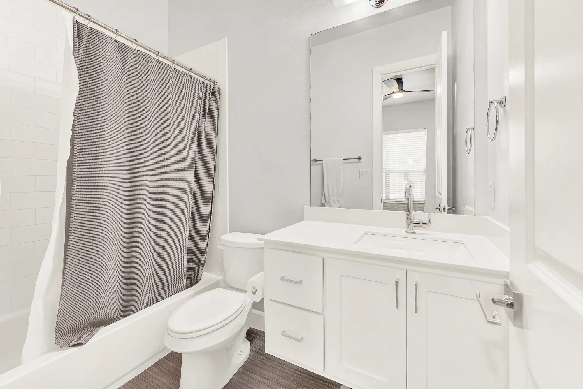 Contemporary bathroom featuring a white vanity with a recessed sink, brushed nickel faucet, and a large wall-mounted mirror