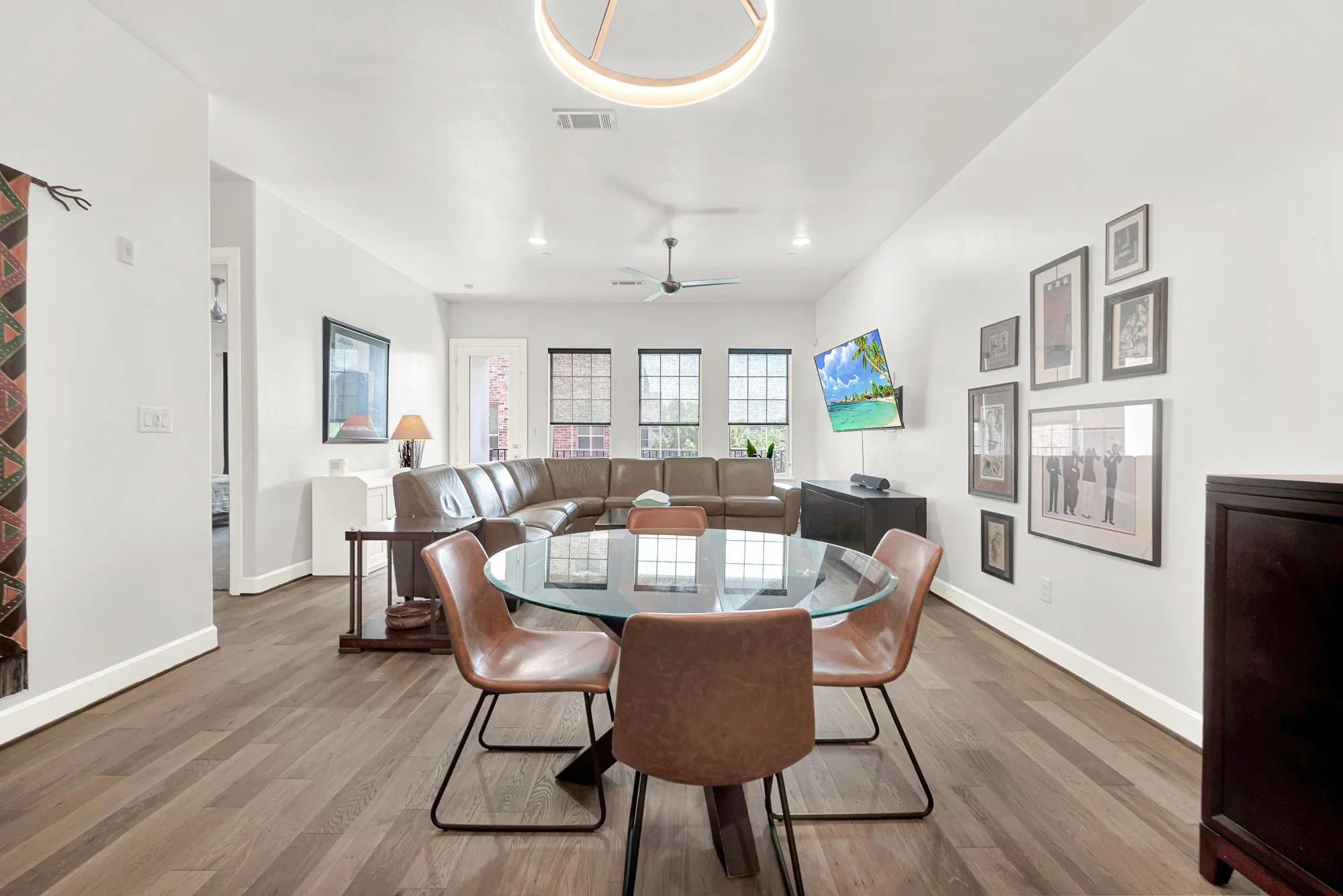 Open-concept living area featuring wood-finish flooring, white walls, and a recessed ceiling light