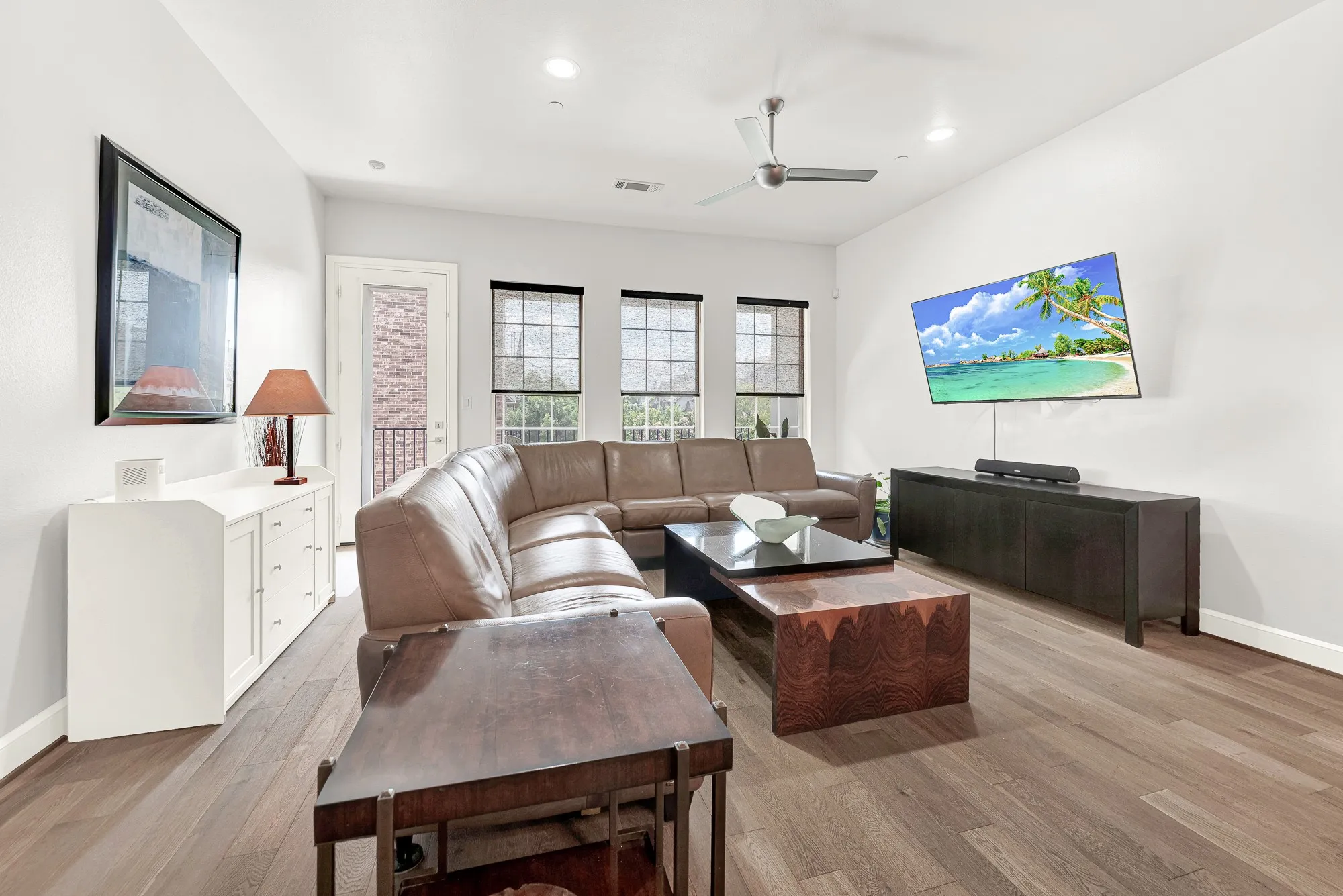Spacious living area featuring wood-finish flooring, recessed lighting, and a ceiling fan
