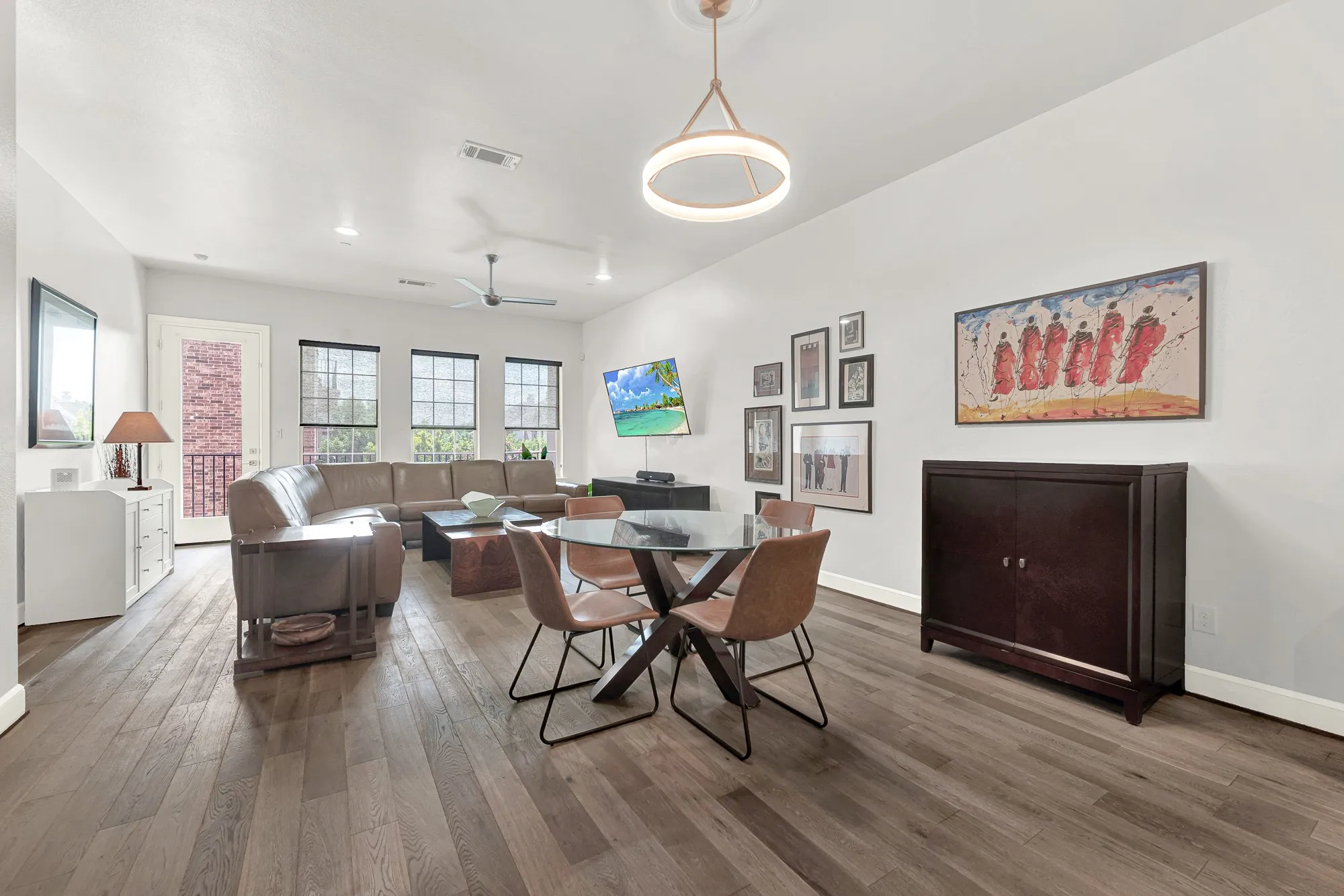 Open-concept living area with wide plank wood-finish flooring, recessed lighting, and a modern ceiling fan