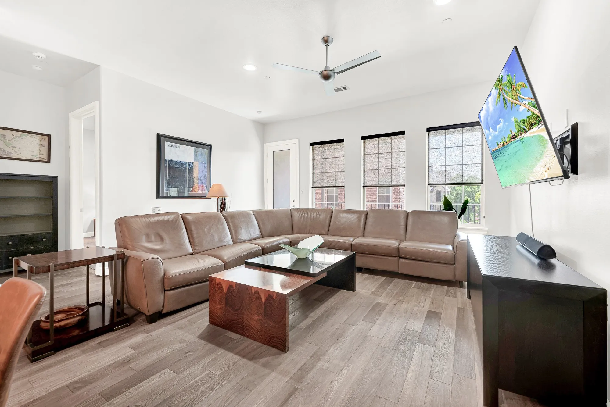 Spacious living area featuring wood-finish flooring, recessed lighting, and a modern ceiling fan