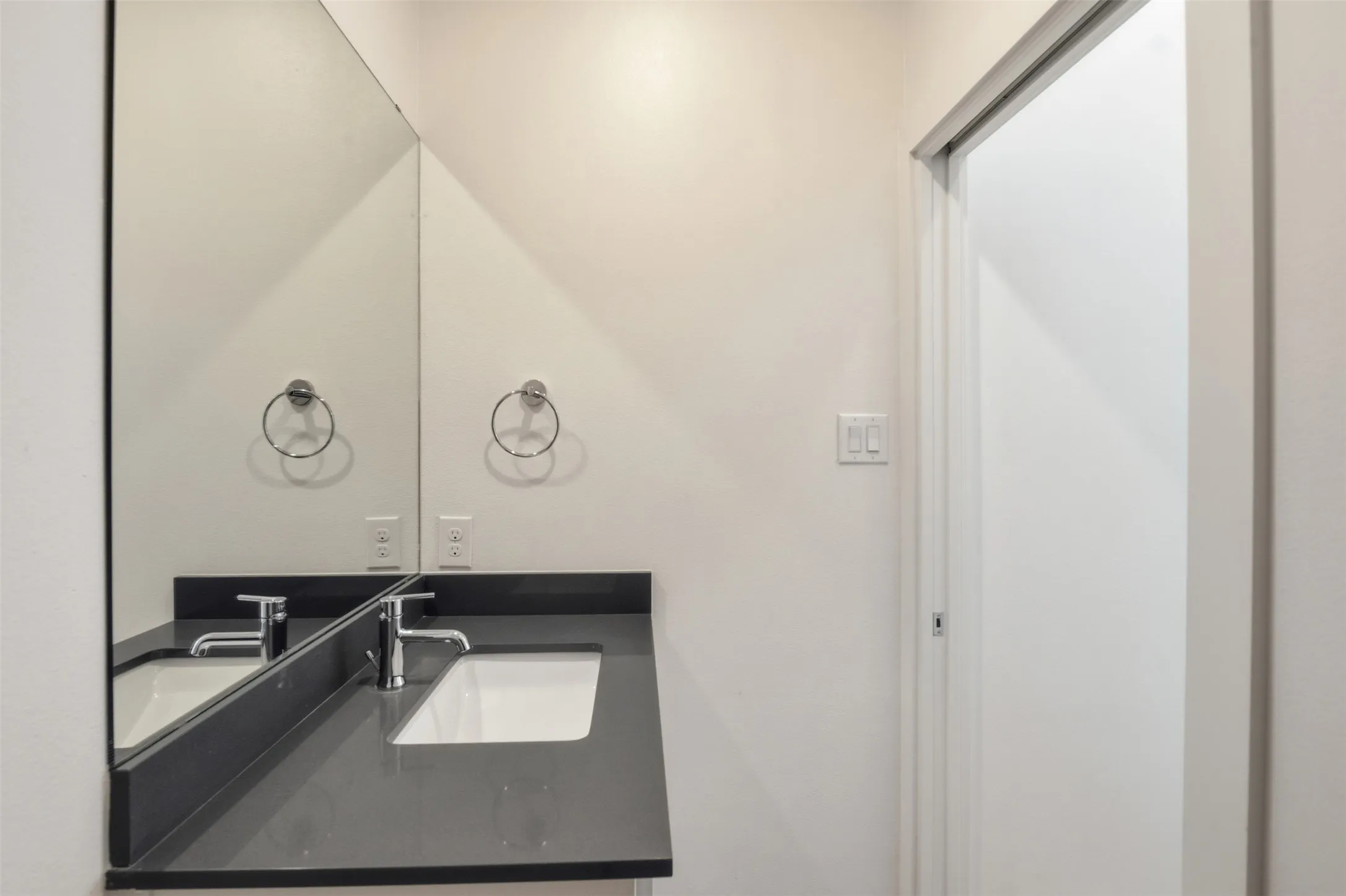 Powder room adjacent to laundry with full size stackable unit.