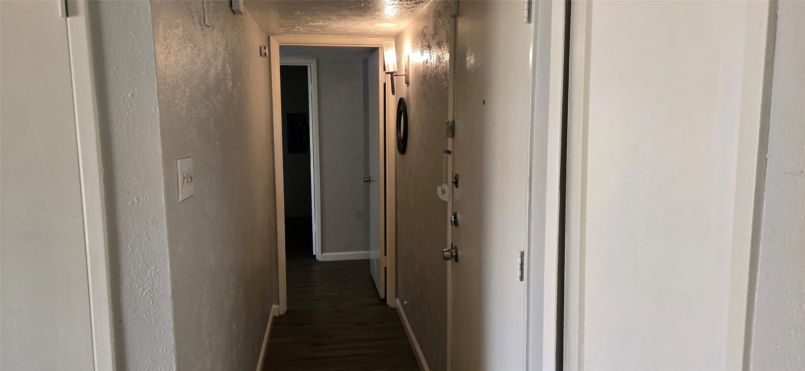 Hallway with wood-finish flooring and light-toned walls