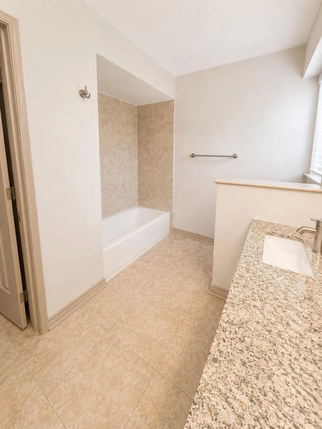 Bathroom featuring a full vanity with an integrated sink, polished chrome faucet, and stone-finish countertop