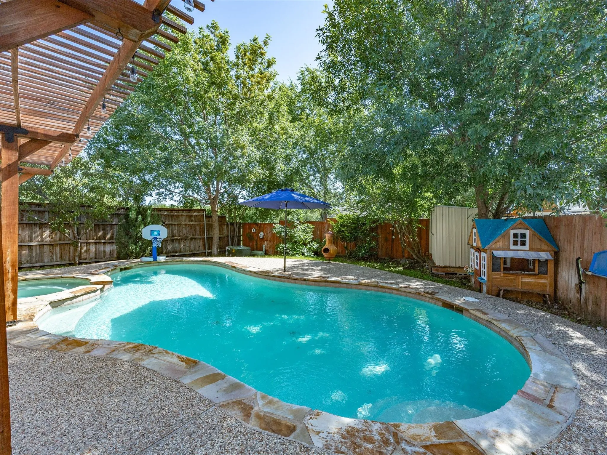 Swimming pool featuring a flagstone coping and a textured concrete deck