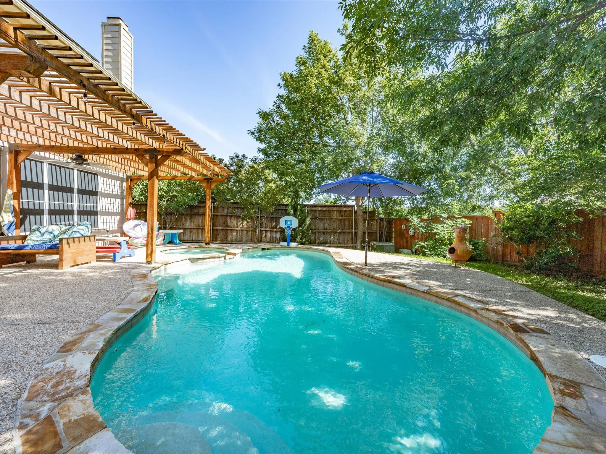 Swimming pool featuring a flagstone coping and a textured concrete deck