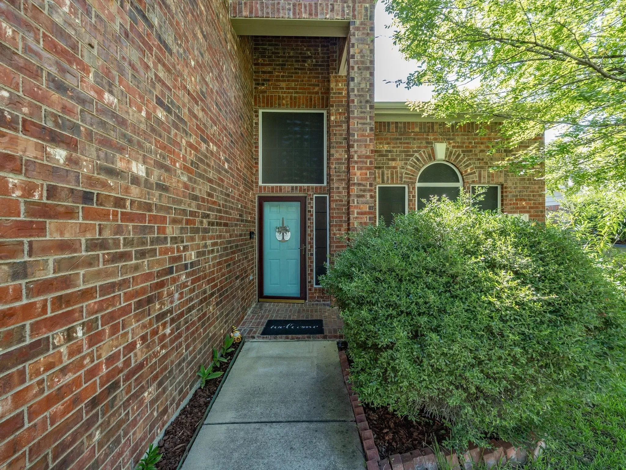 Brick exterior with a prominent turquoise entry door