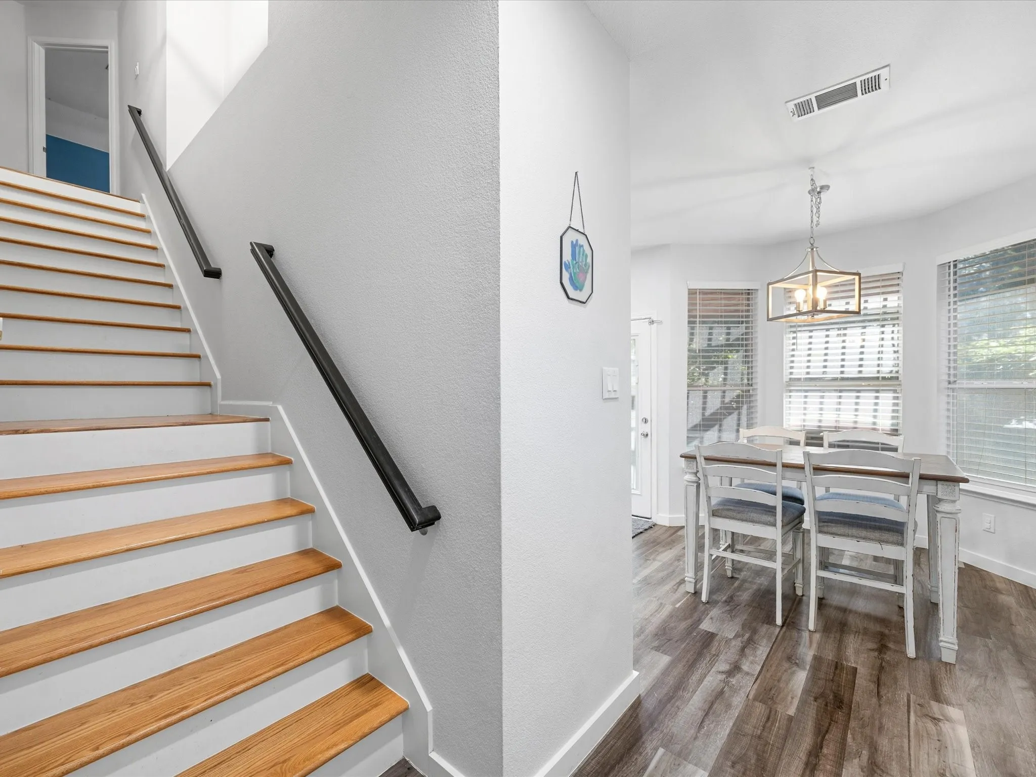Staircase with wood-finish treads and black handrails
