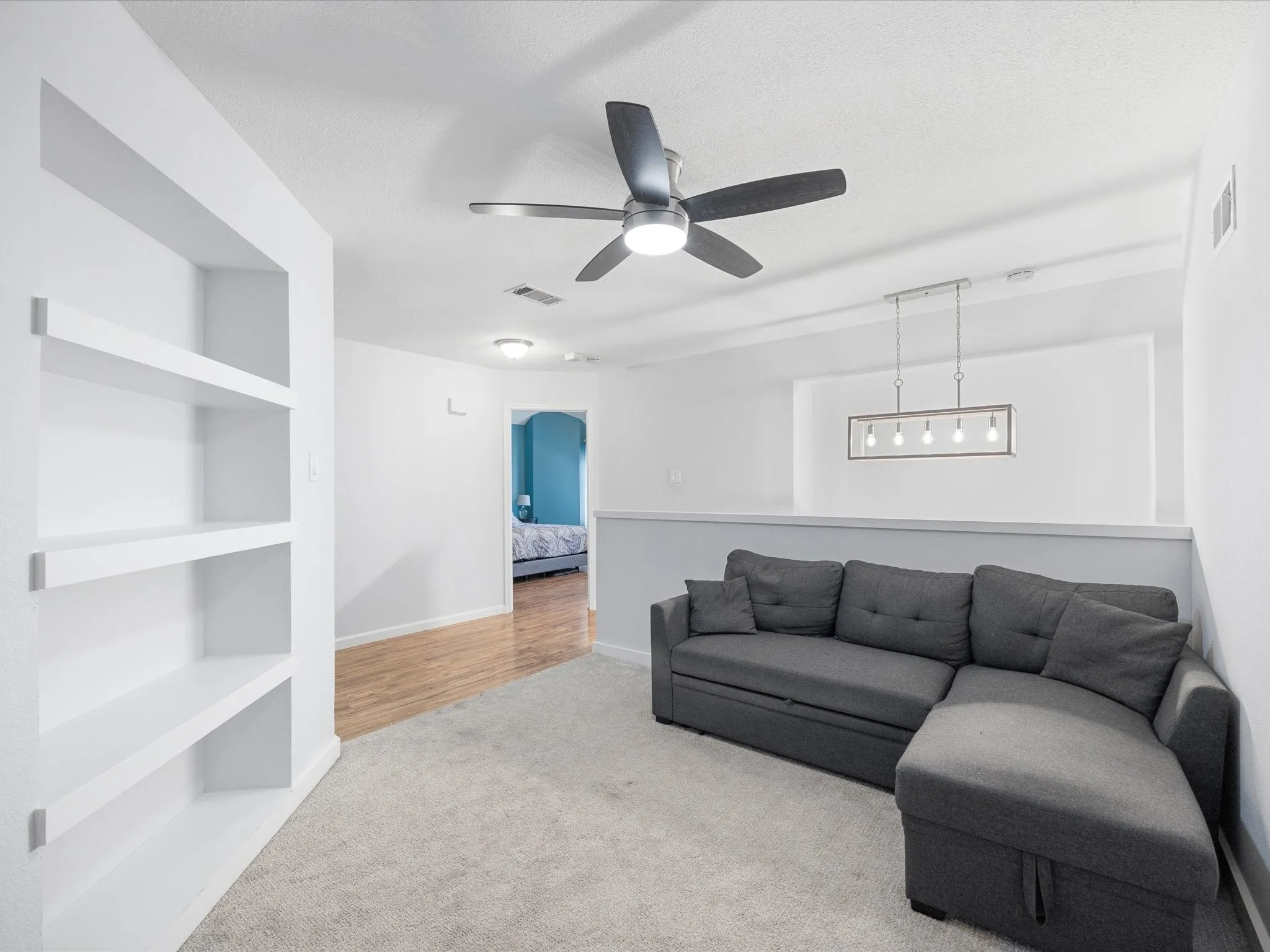 Upper-level living area with recessed lighting, a modern ceiling fan, and a contemporary linear chandelier