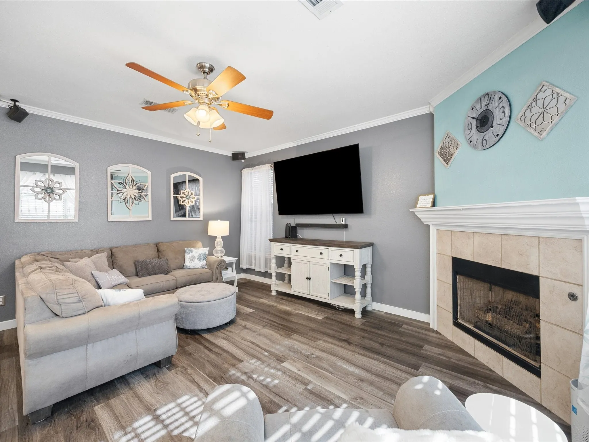 Wood-finish flooring throughout, featuring a corner fireplace with a tiled surround and white mantel