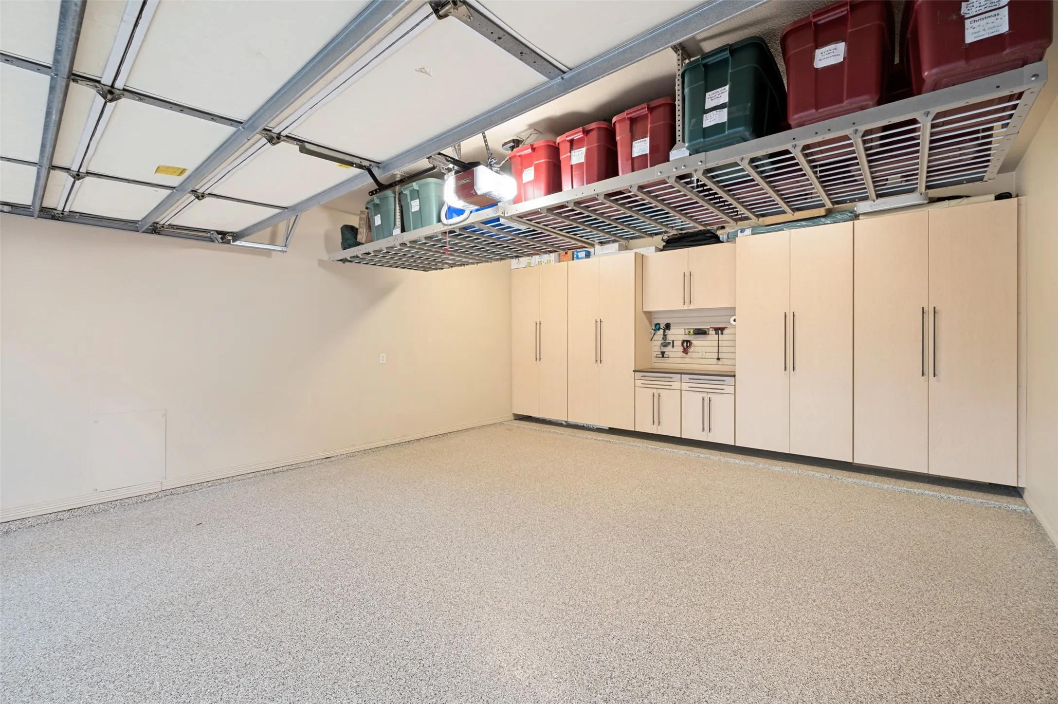 Garage features epoxy floors, custom cabinetry, and additional storage racks.