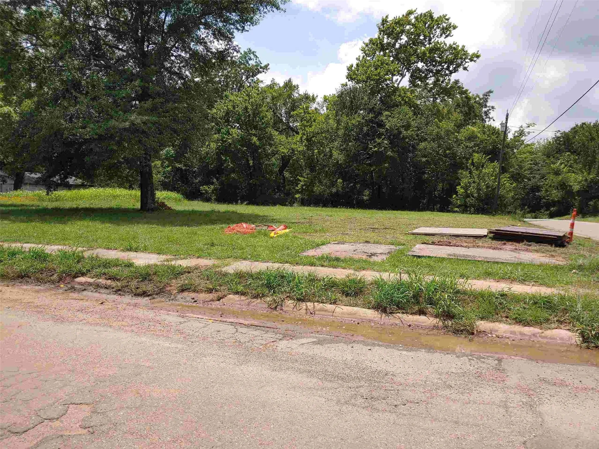 Corner lot with mature trees and grass