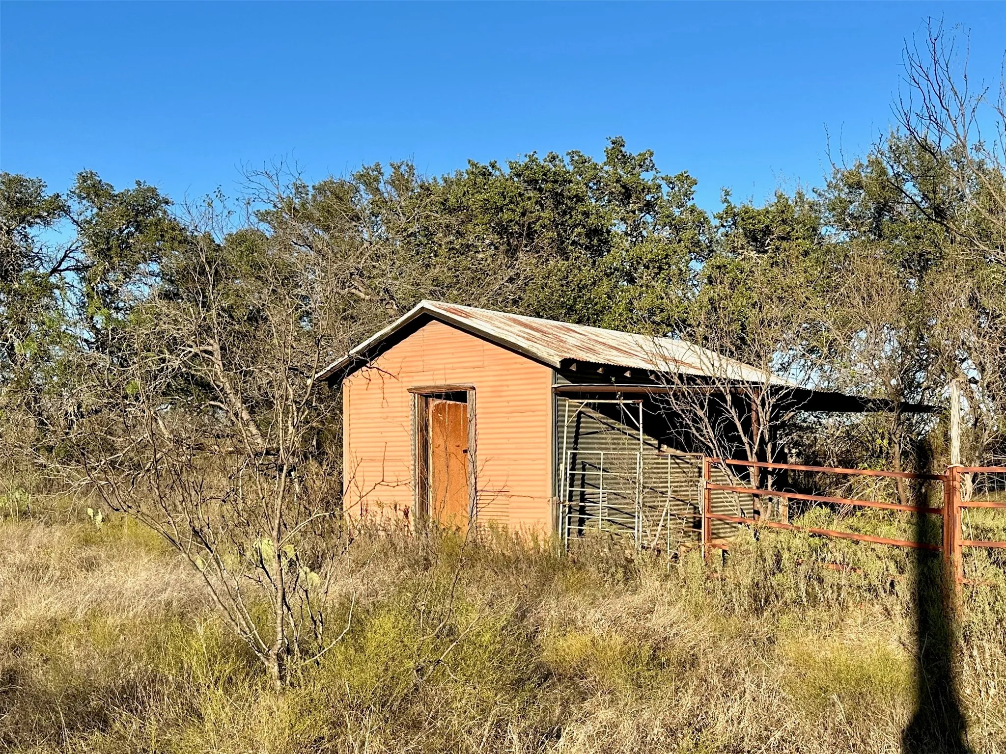 Rustic shed with a corrugated metal roof and an attached lean-to structure