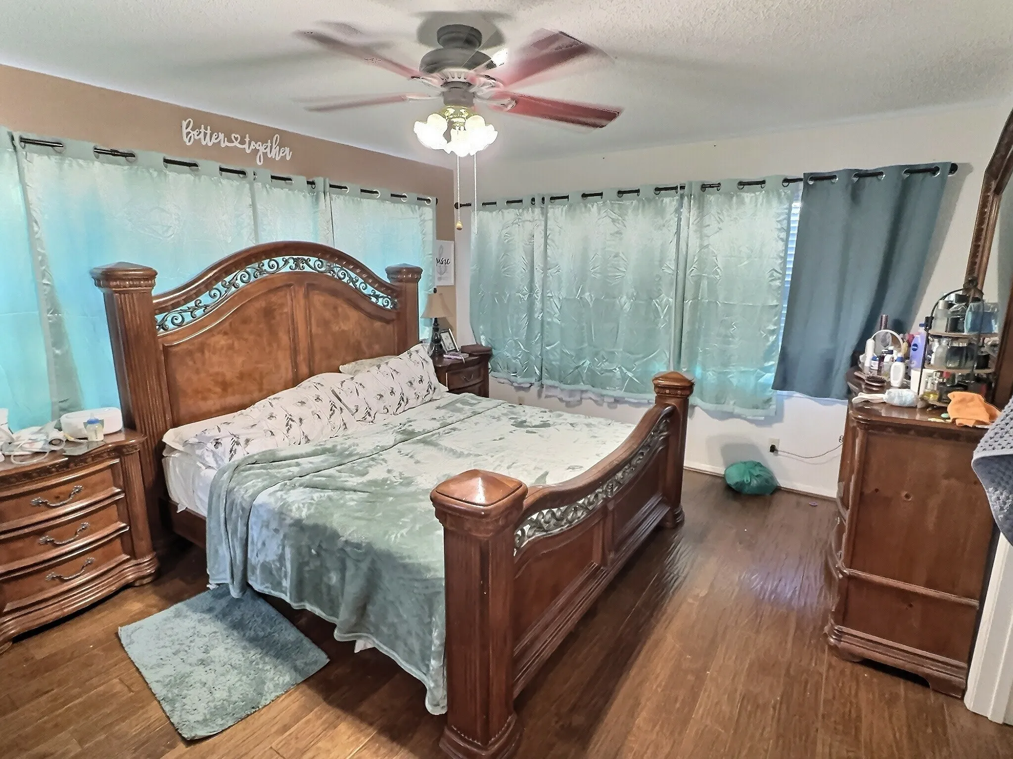 Bedroom featuring wood-finish flooring, multiple windows, and a ceiling fan with integrated lighting