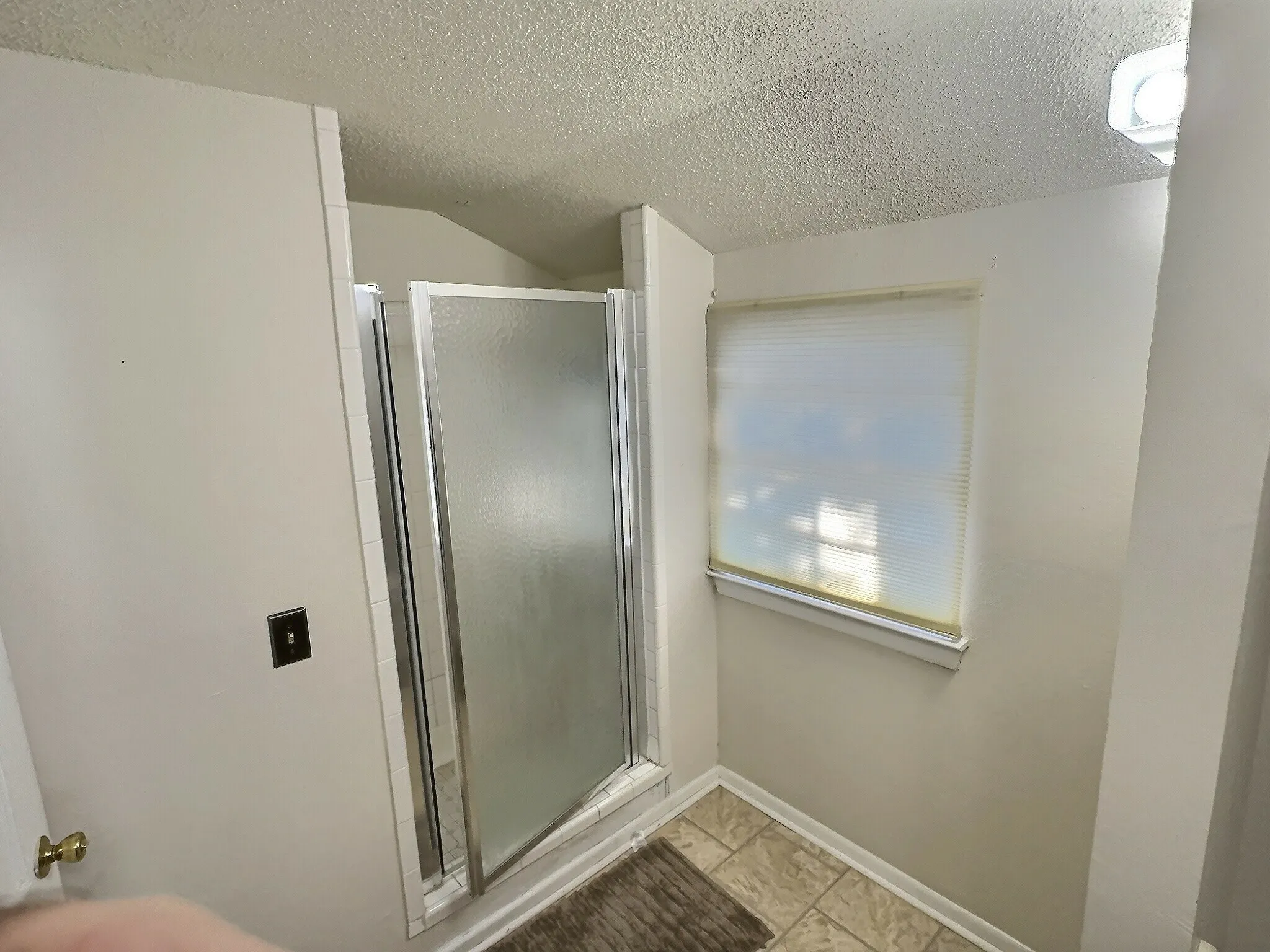 Shower enclosure featuring frosted glass doors and a chrome frame
