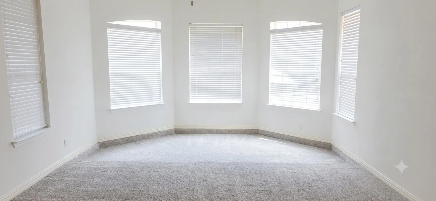 Bay window feature with multiple windows, carpet flooring, baseboard molding, and a ceiling fan
