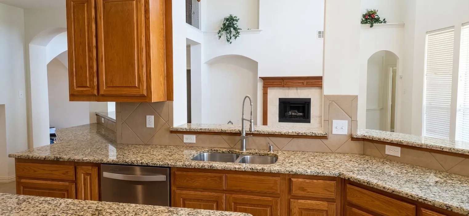 Kitchen featuring granite countertops, wood cabinetry, stainless steel sink with gooseneck faucet, and tile backsplash