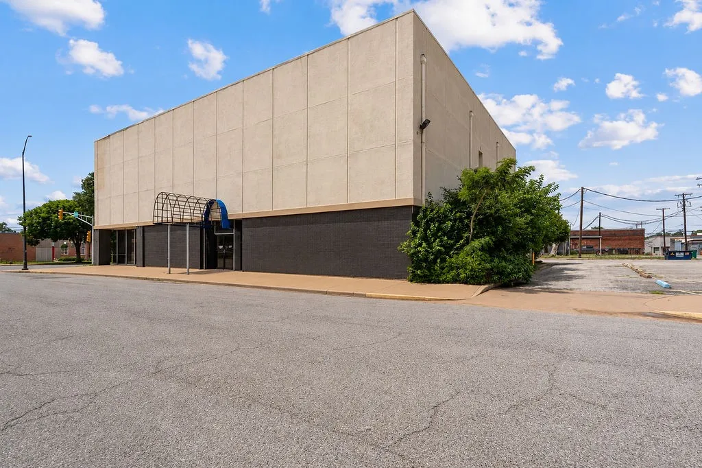 Commercial building featuring a cream-colored upper facade and a dark gray lower facade