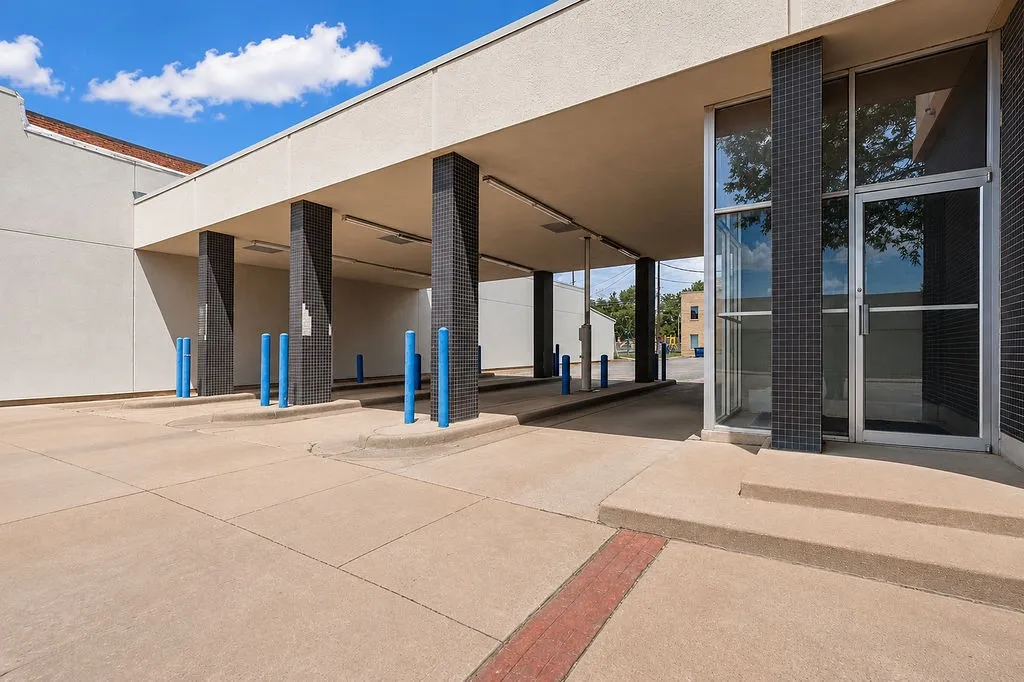 Drive-through lanes with concrete paving and blue safety bollards