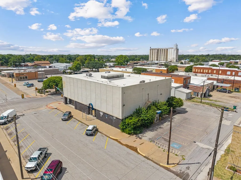 Commercial building featuring a flat roofline, neutral-toned exterior, and an adjacent paved parking area