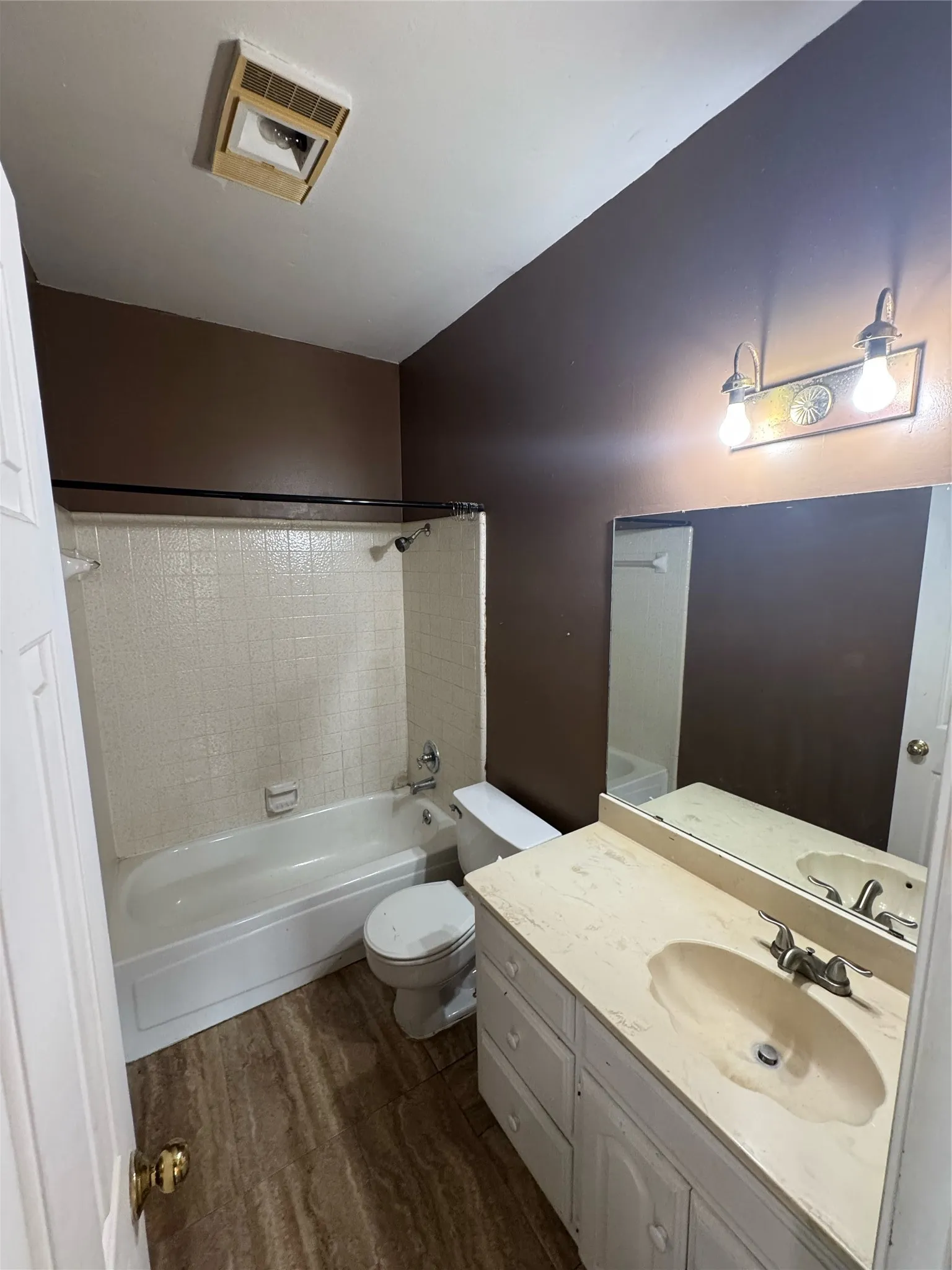 Bathroom featuring a white vanity with integrated sink, a light-colored countertop, and a wall-mounted mirror
