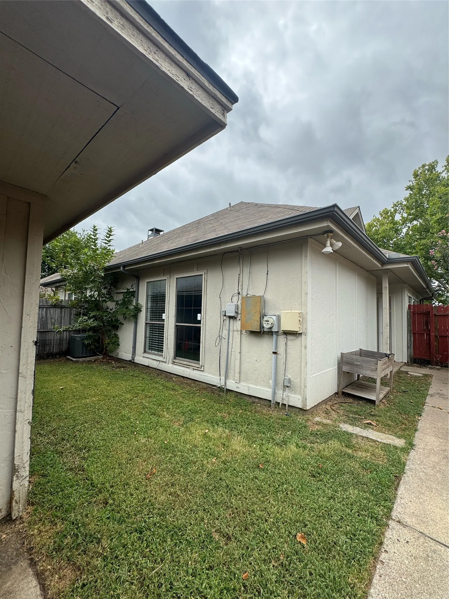 Side yard with grass and concrete walkway