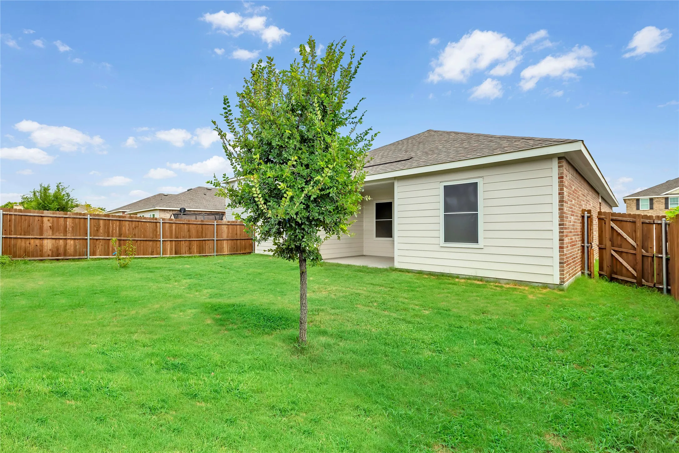 Expansive green lawn and perimeter wood fencing