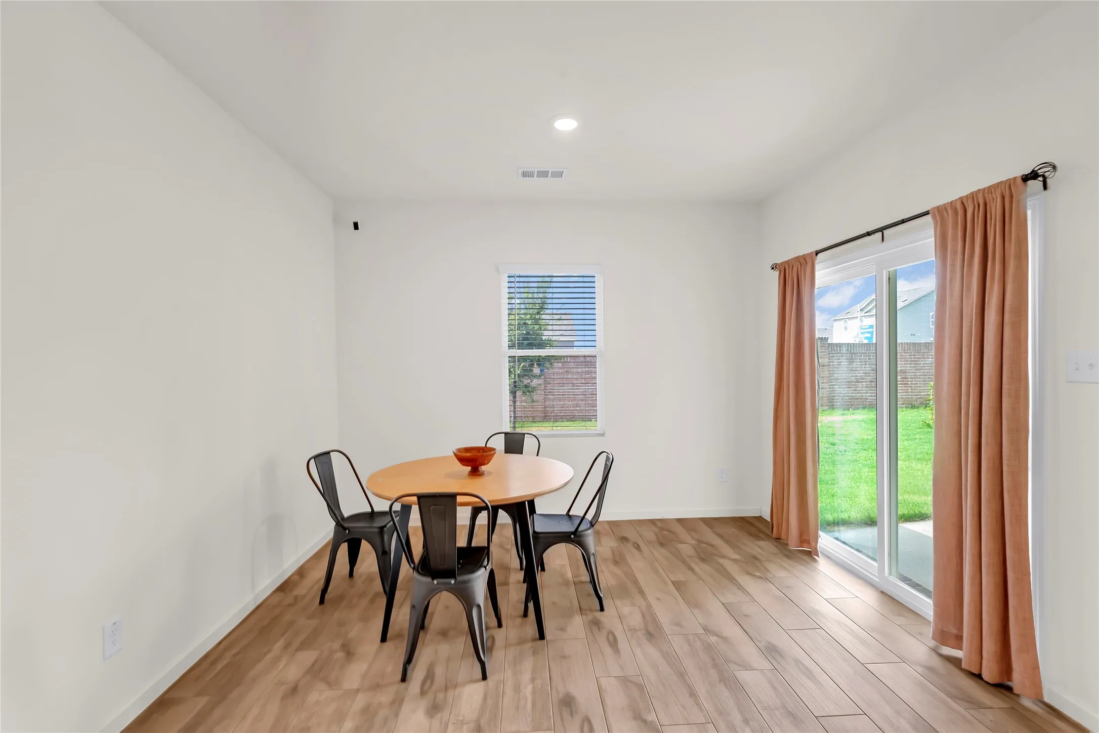 Dining area with wood-finish flooring, recessed lighting, and a sliding glass door to the exterior