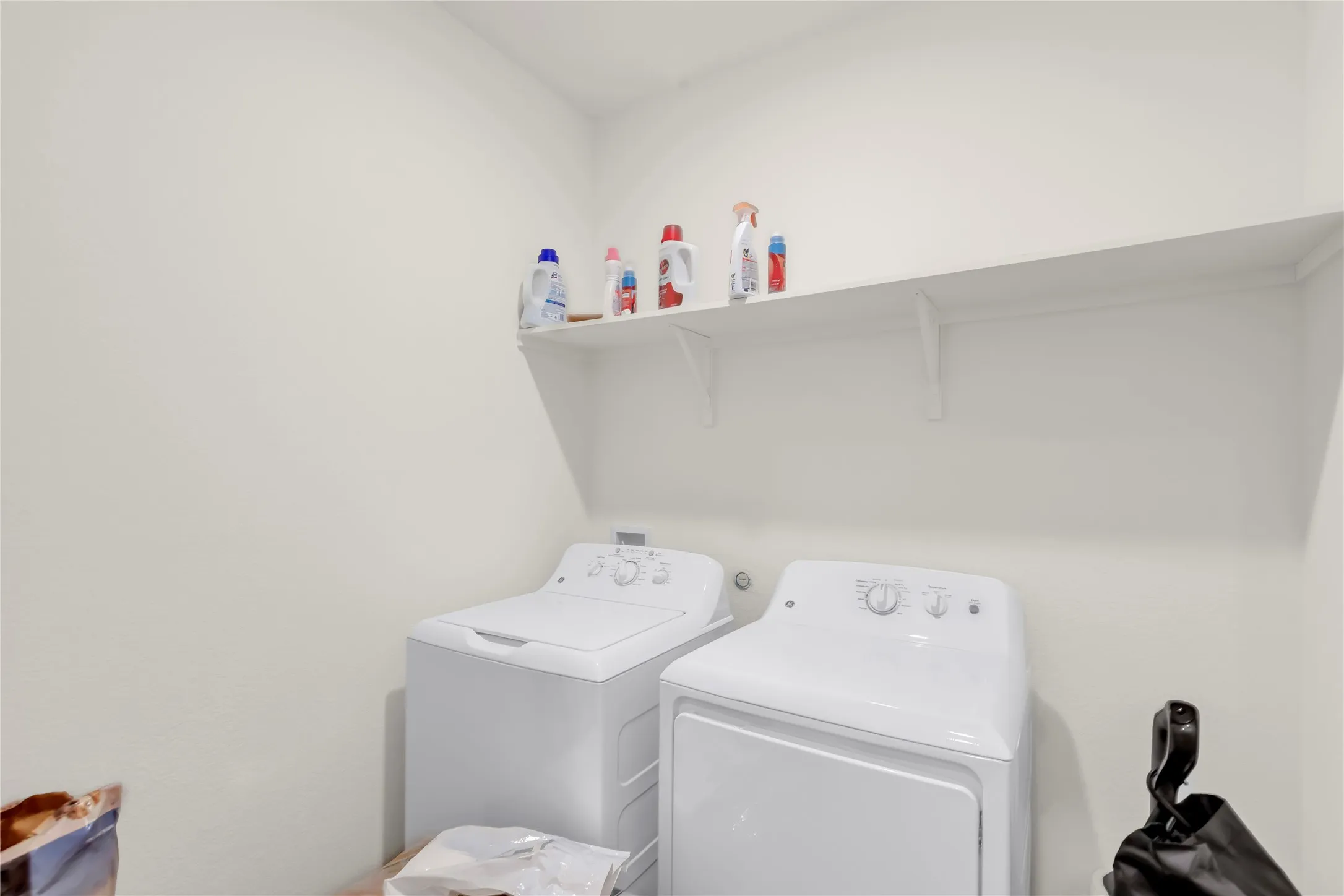 Dedicated laundry area featuring a white storage shelf