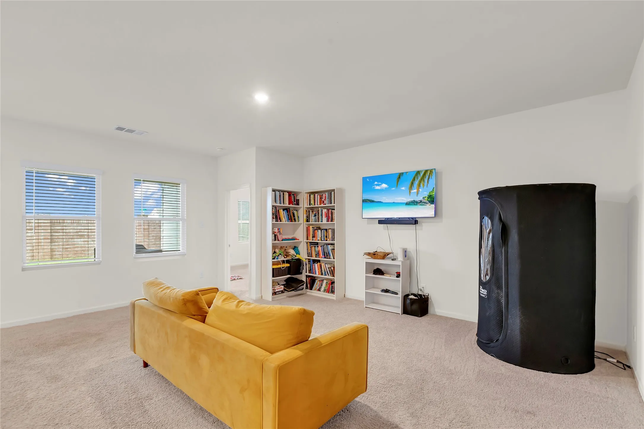 Spacious room featuring neutral carpeting and white walls