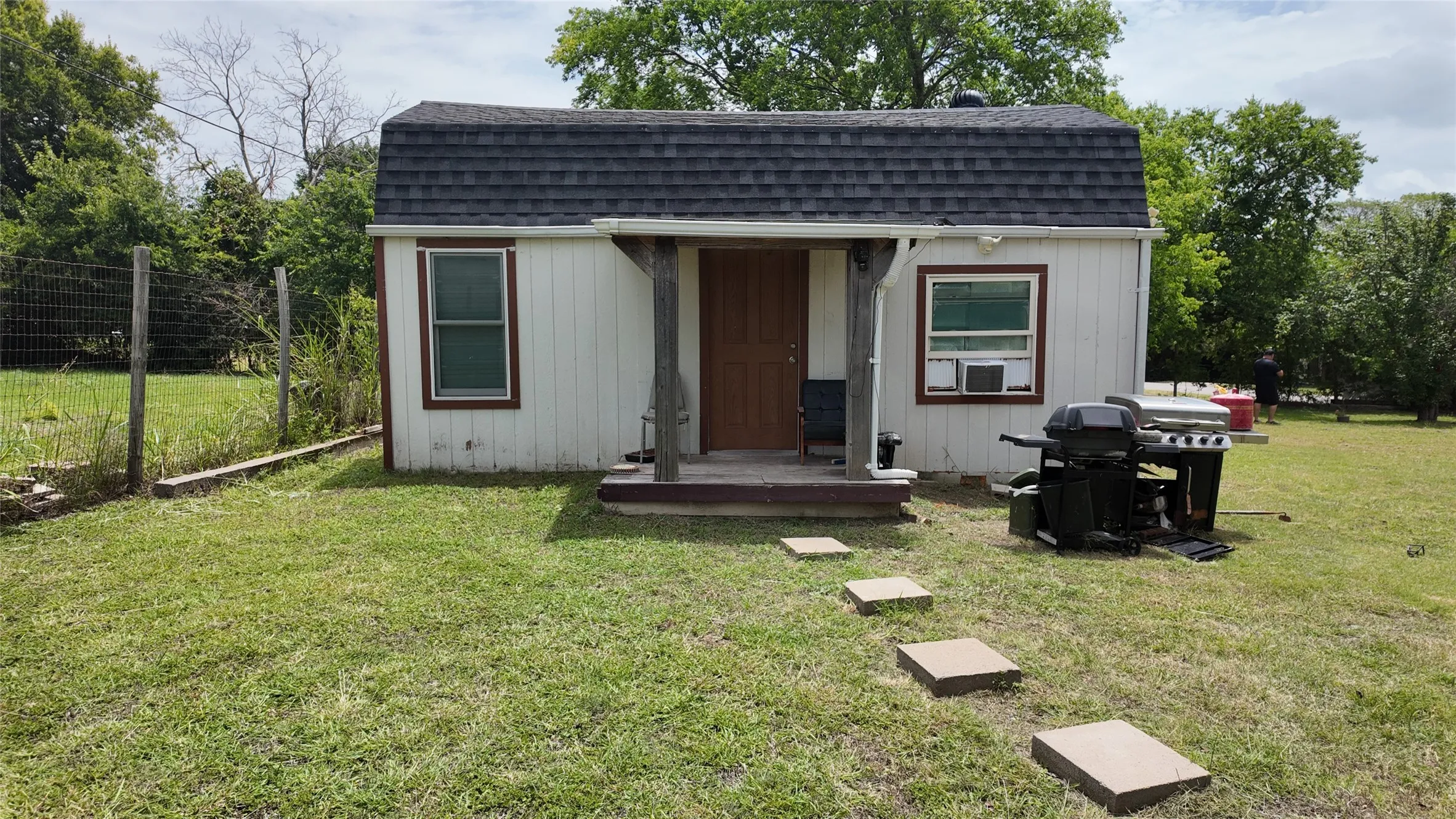 Freestanding structure featuring a gambrel roof and vinyl siding