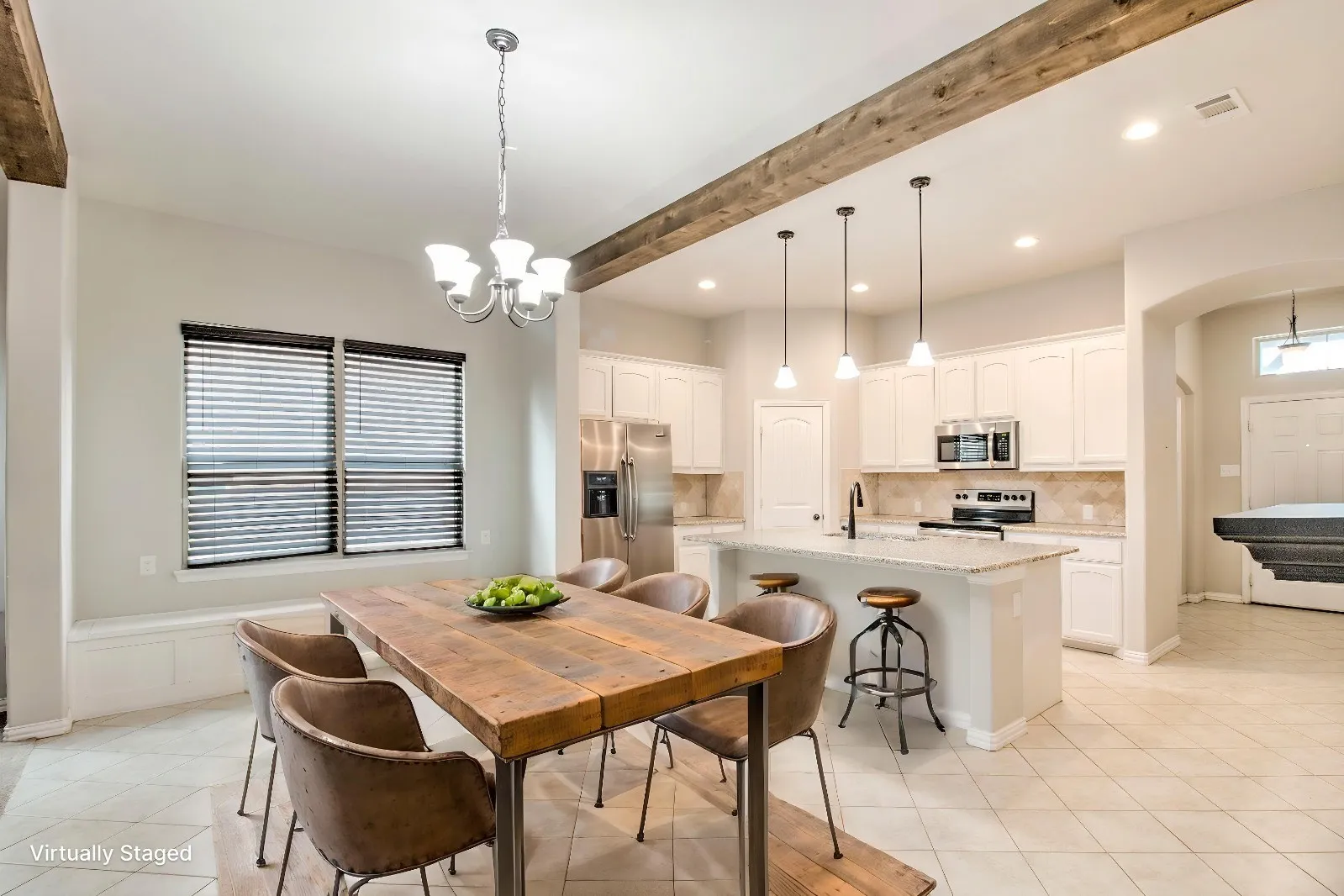 Open-concept kitchen and dining area featuring white cabinetry, a built-in bench, a kitchen island with pendant lighting, and tiled flooring