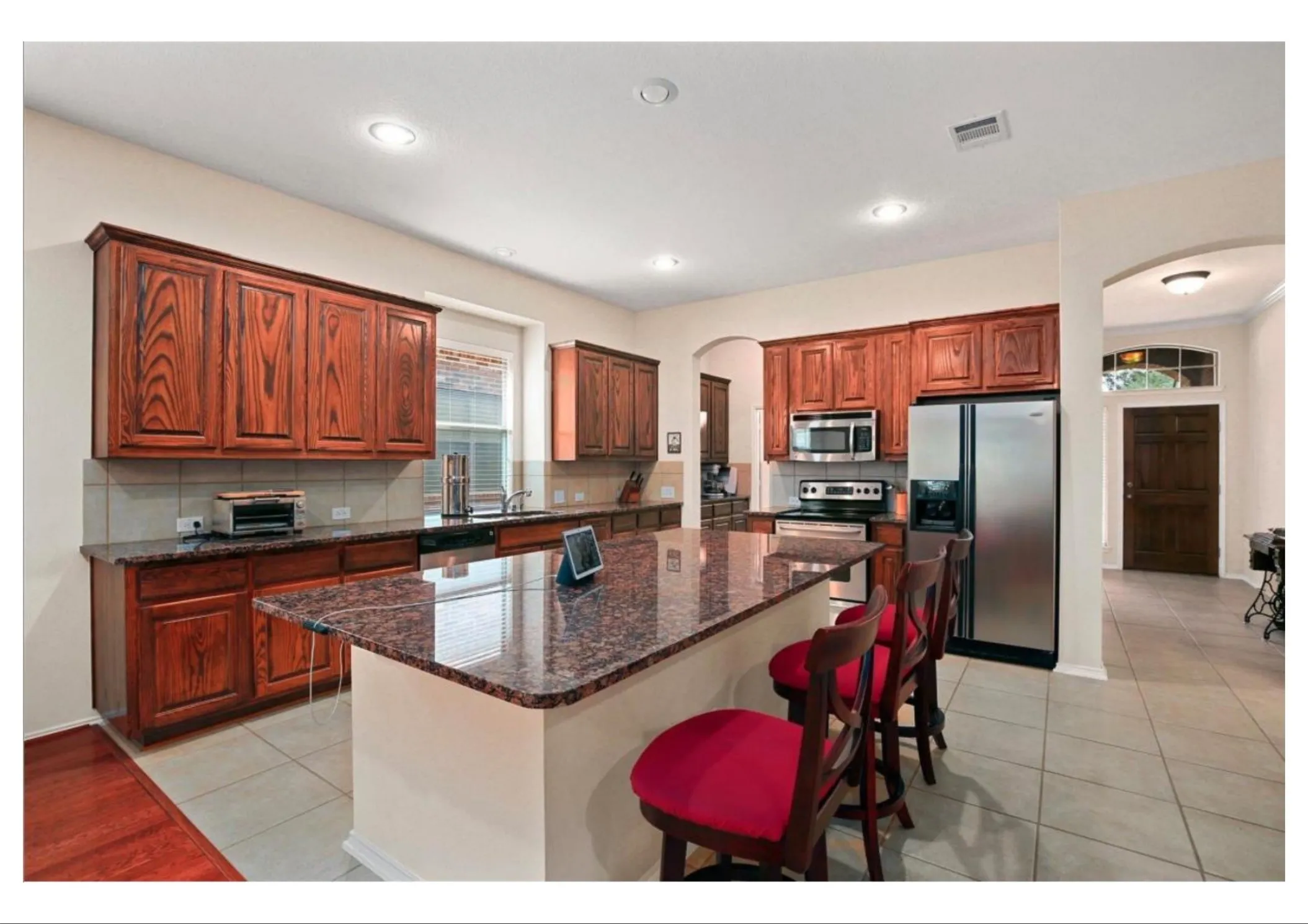 Kitchen featuring wood cabinetry, a center island with countertop seating, stainless steel appliances, and recessed lighting