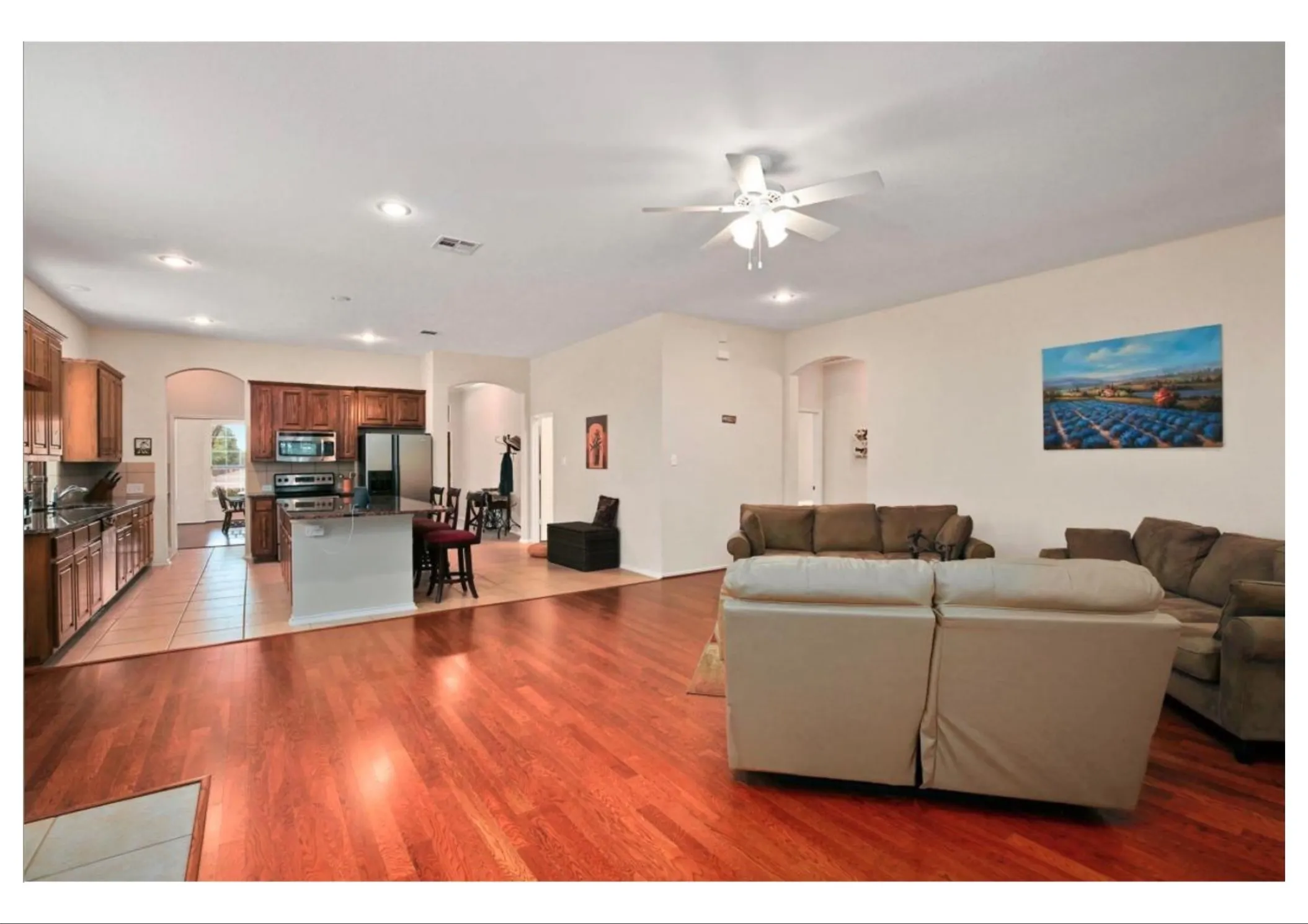 Open-concept living space featuring wood-finish flooring and recessed lighting