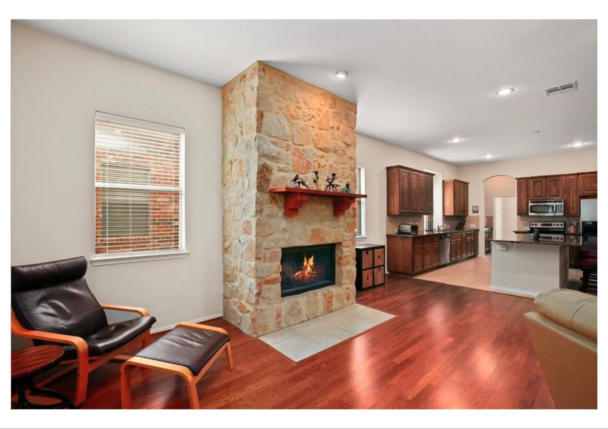 Stone-clad fireplace with a recessed firebox and wood mantel shelf