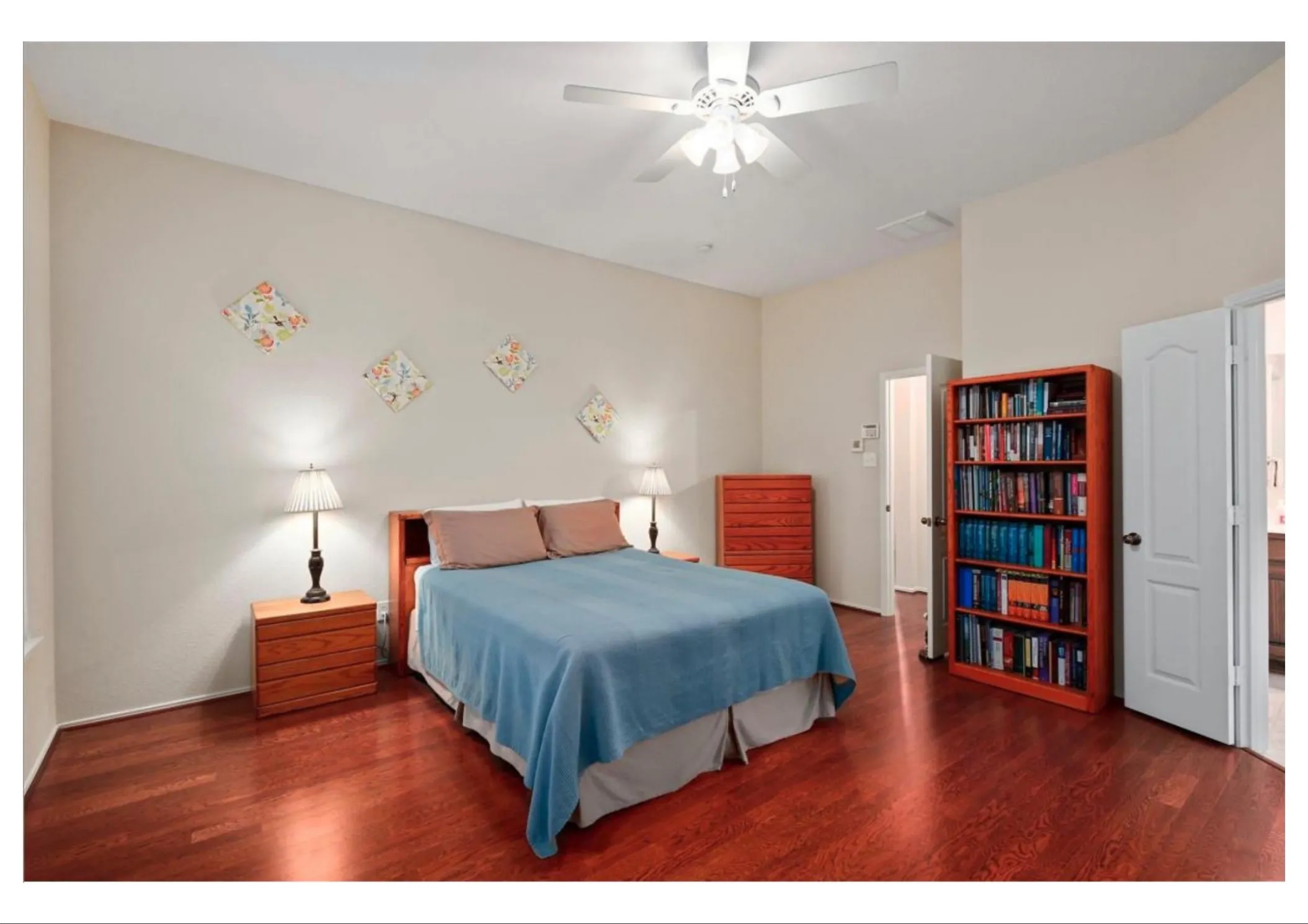 Spacious room featuring wood-finish flooring, a ceiling fan with integrated lighting, and neutral wall tones
