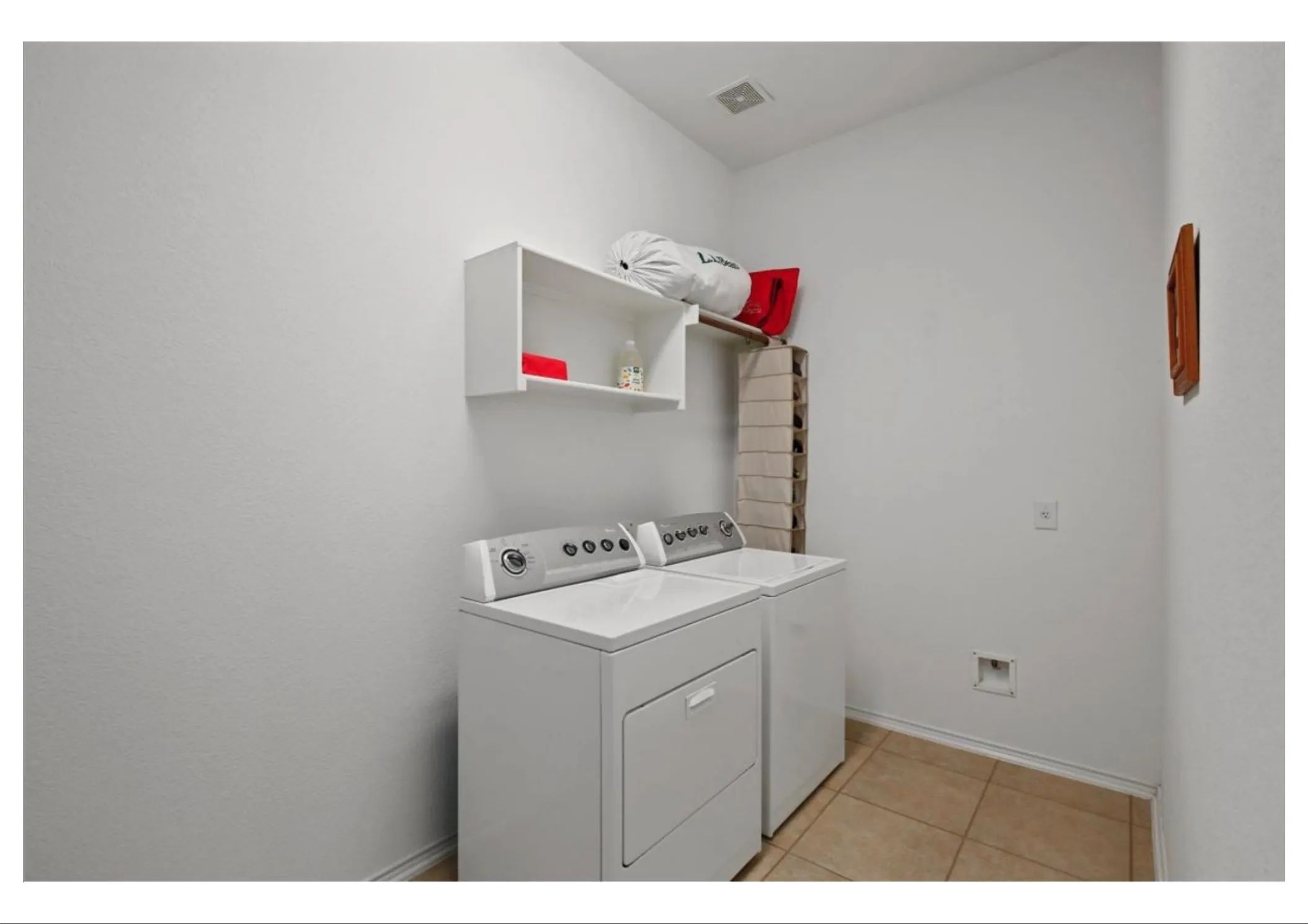 Utility space featuring tiled flooring and a wall-mounted shelving unit