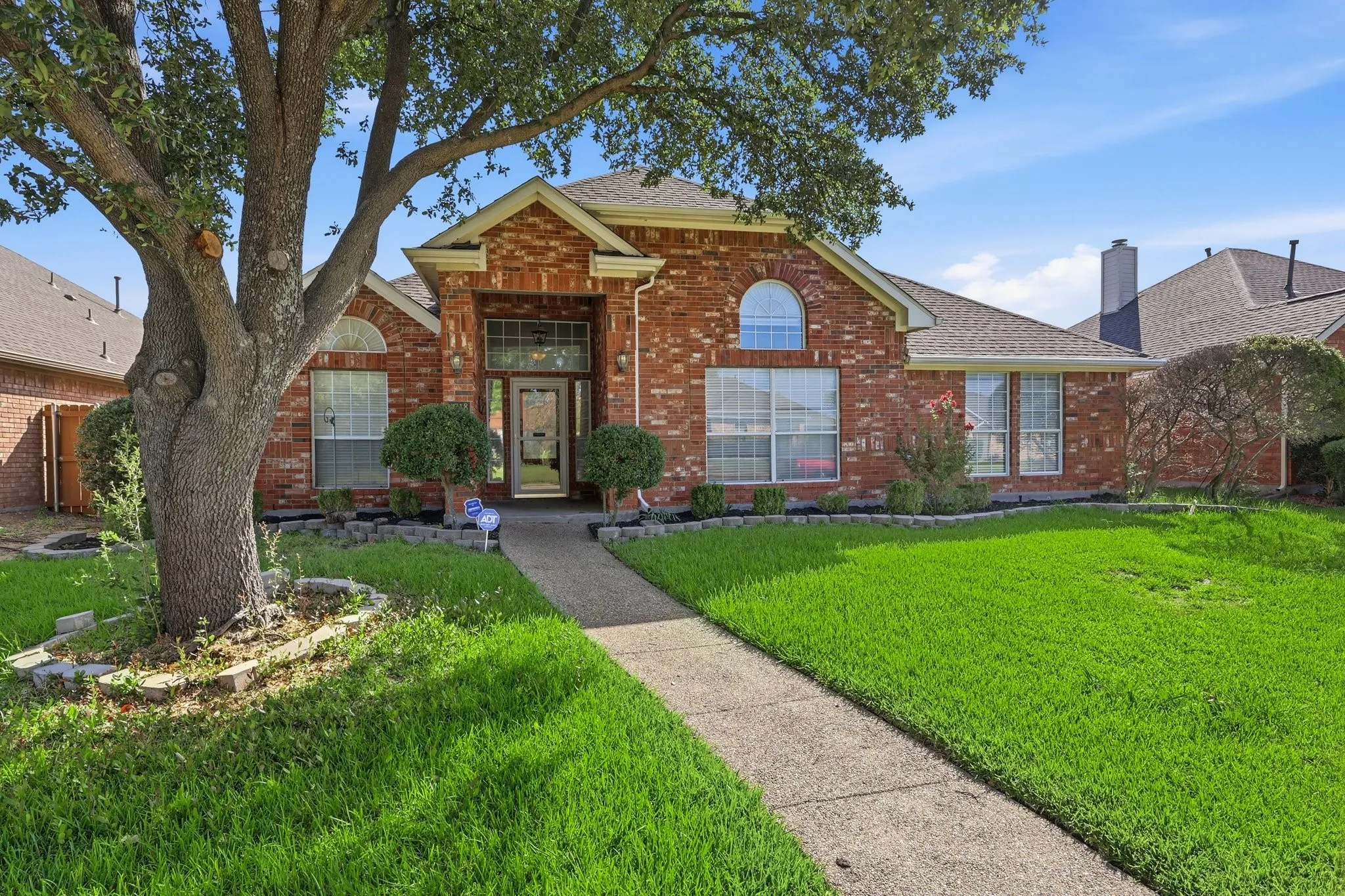 Traditional brick facade featuring arched window accents and a gabled entryway