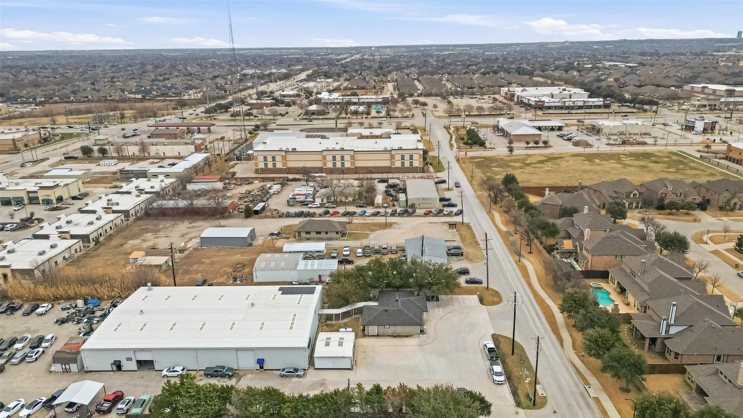 Expansive aerial view showcasing a commercial and residential area with various buildings and infrastructure