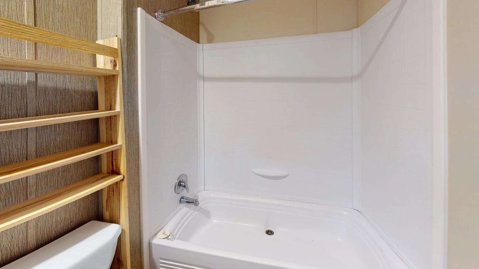 White acrylic bathtub and shower surround with chrome fixtures