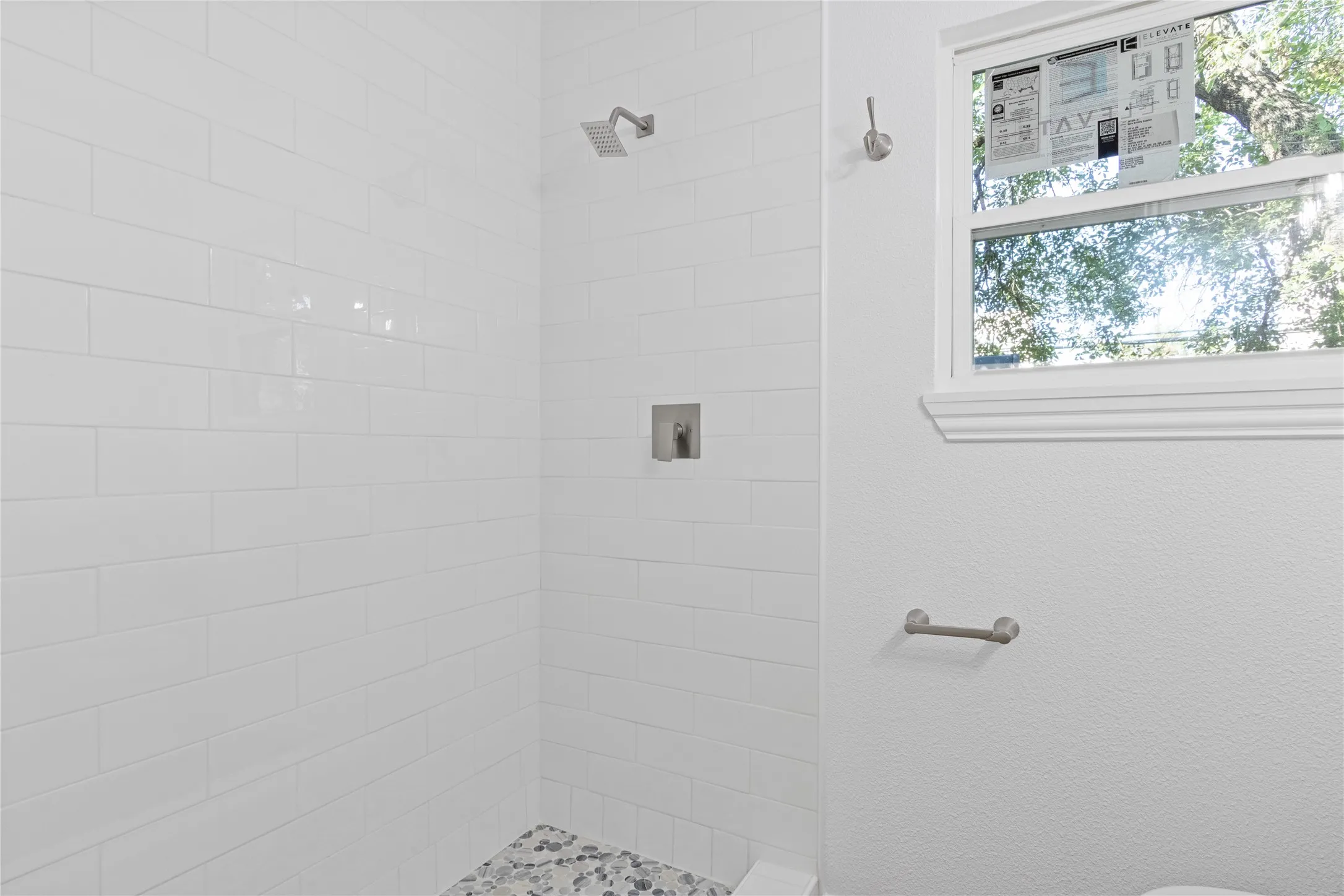 Shower enclosure featuring white subway tile, a recessed niche, and a square rain showerhead