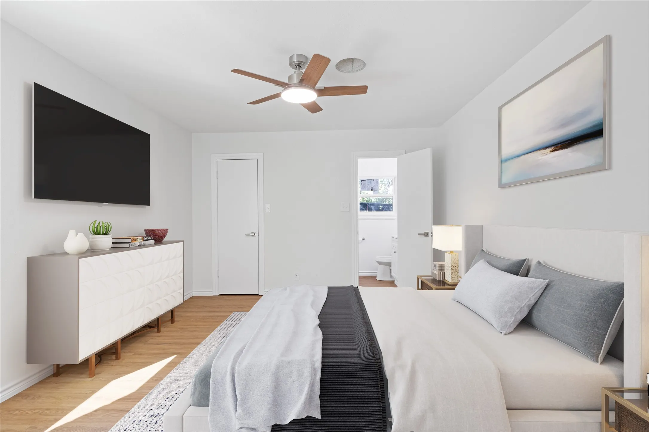 Spacious room featuring wood-finish flooring and a ceiling fan with integrated lighting
