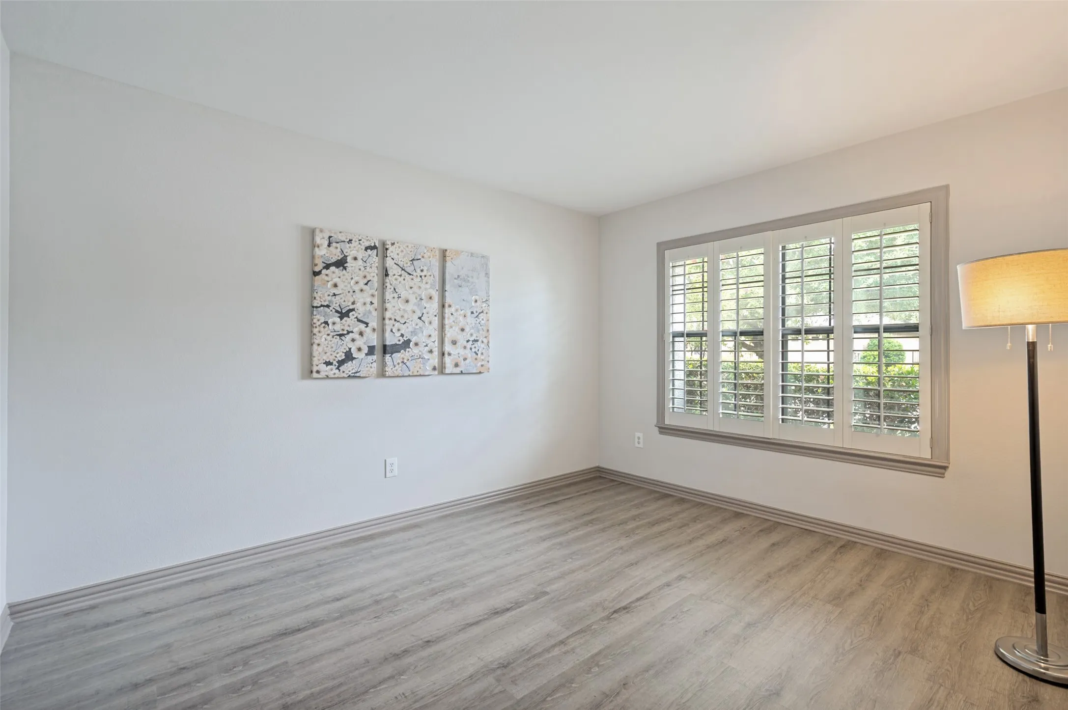 Guest bedroom faces the front of the home and another large oak tree.