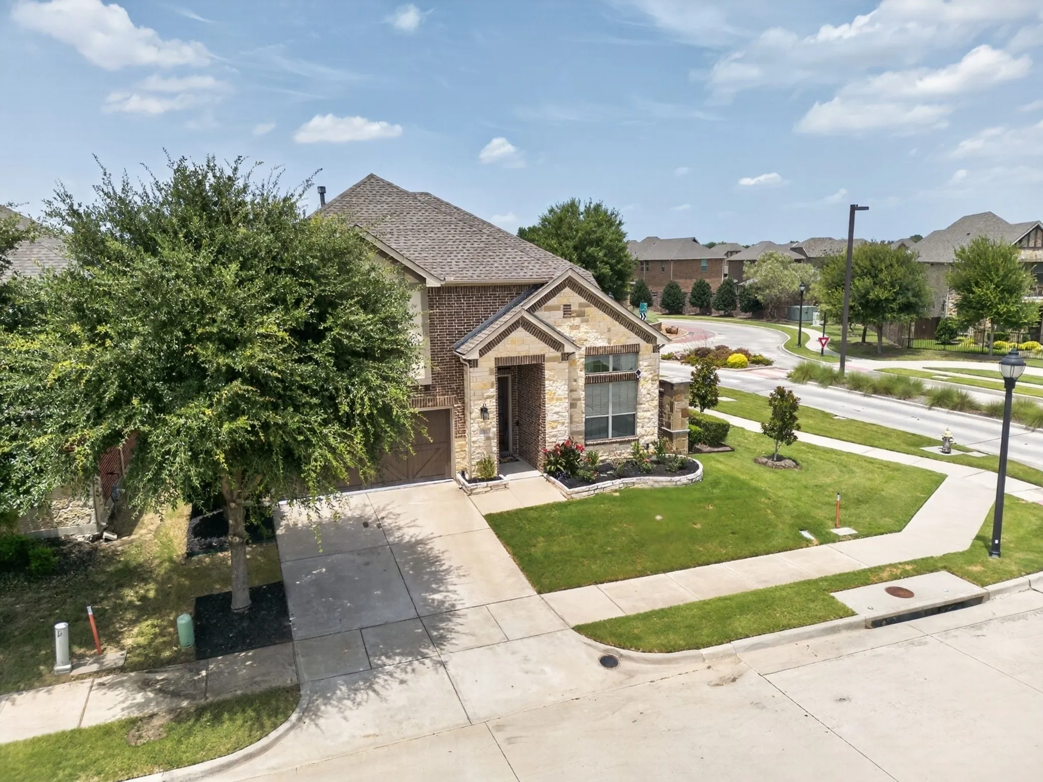 Two-story residence featuring a brick and stone exterior with a gabled roof