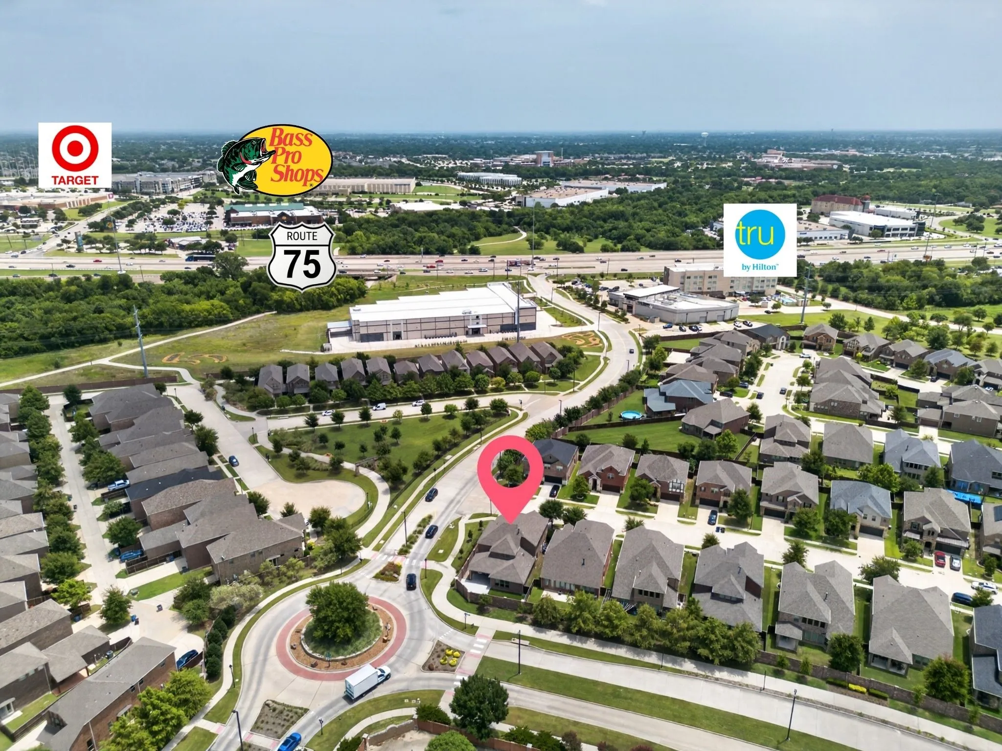 Aerial perspective showcasing a residential neighborhood with varied rooflines and a central roundabout