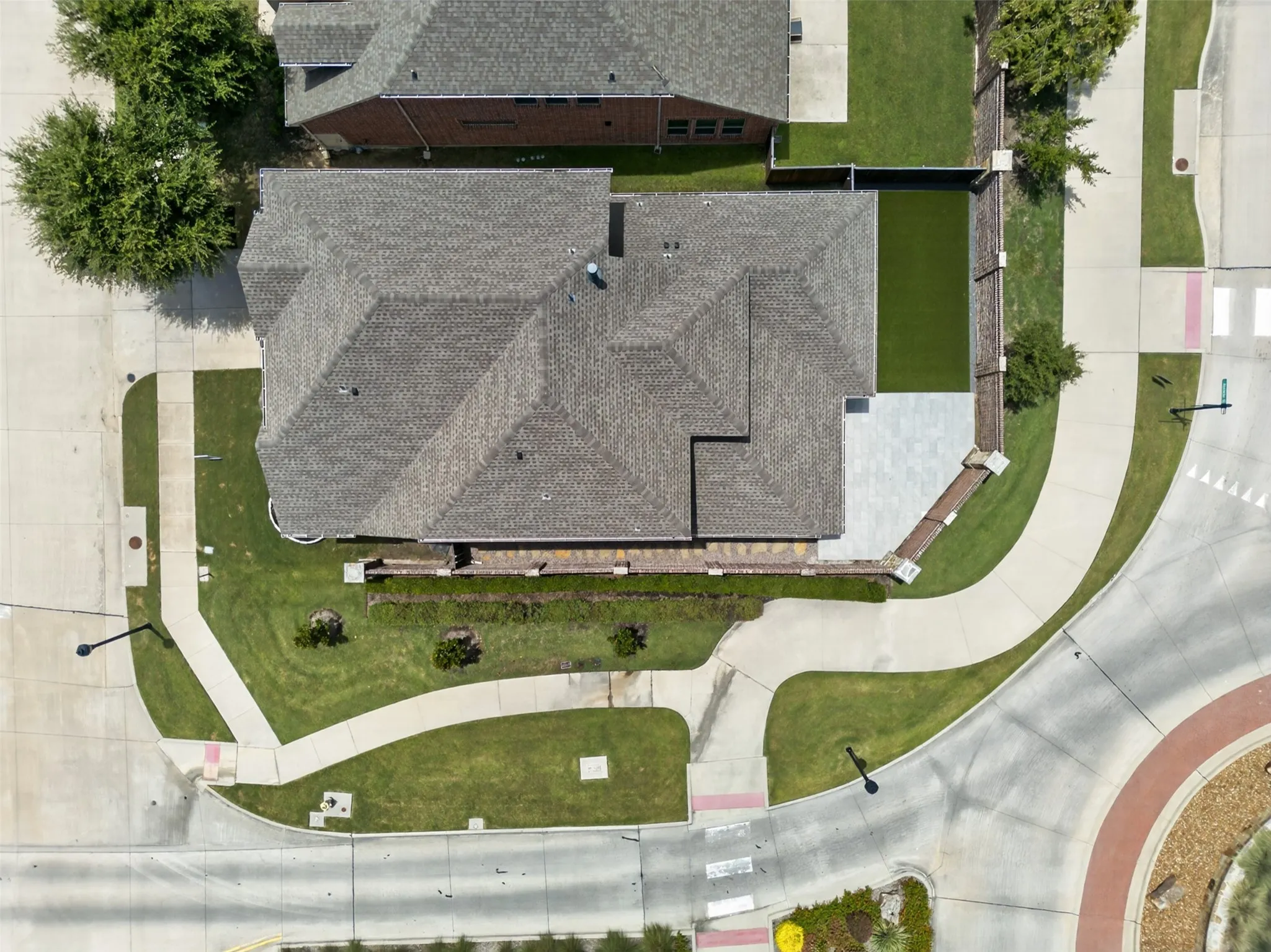 Property with extensive concrete paving, a large roofline, and a rectangular patio area