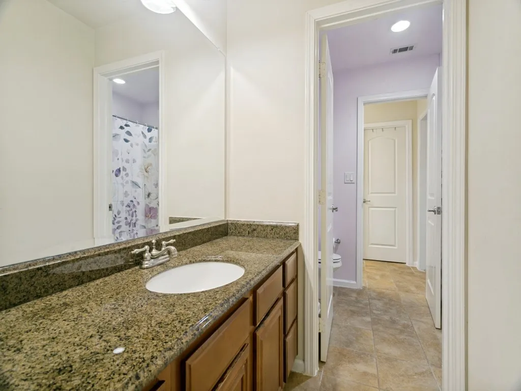 Walk-thru bathroom between bedrooms with private dressing area for each